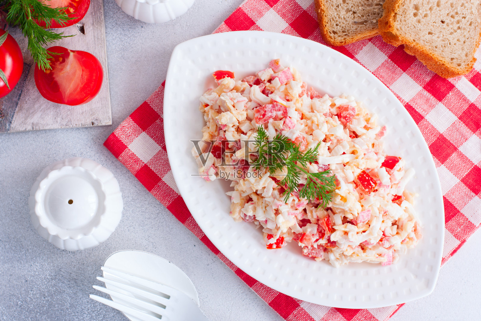 自制沙拉配蟹肉条、番茄、芝士，横放在白碟上照片摄影图片