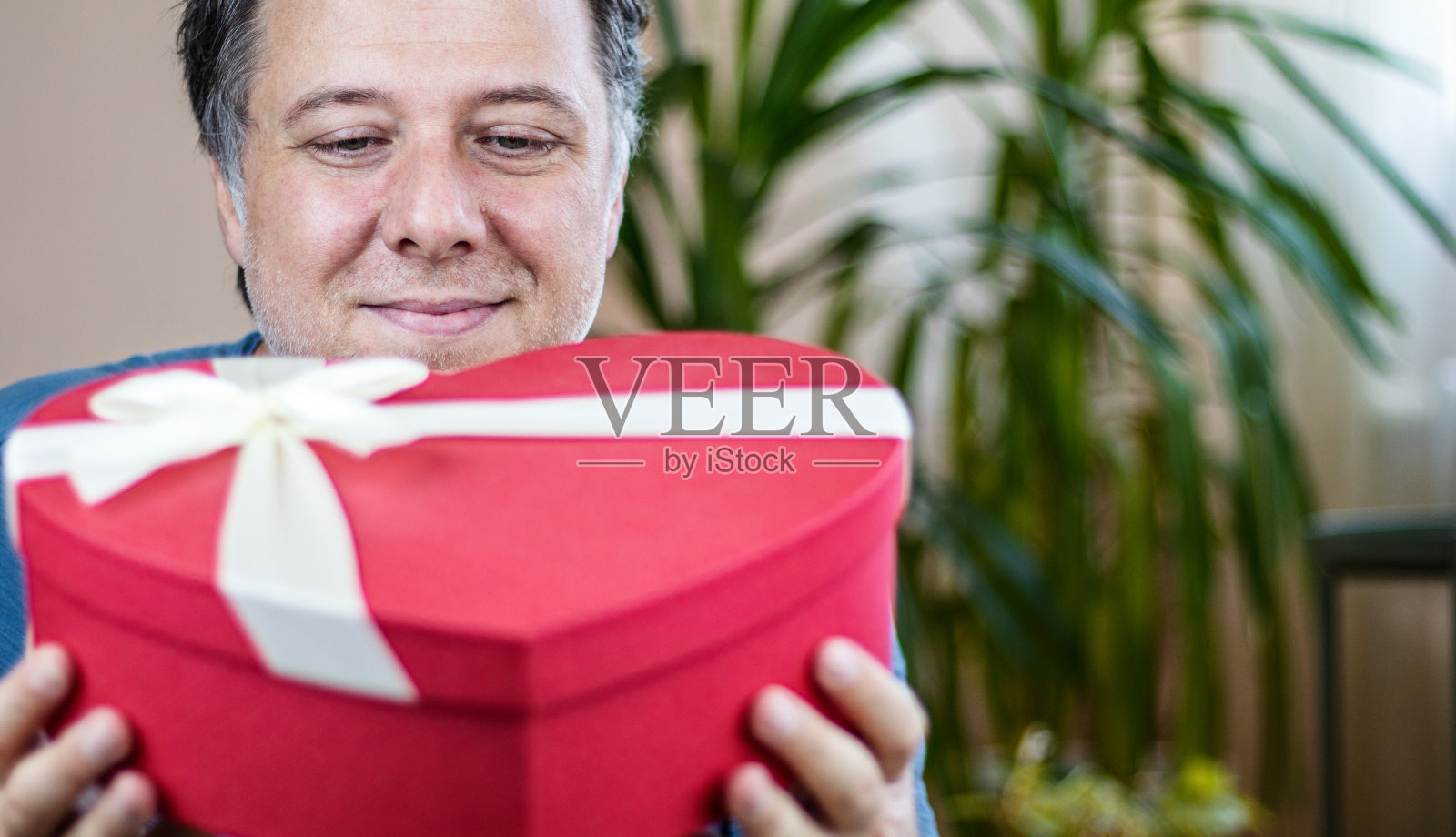 快乐的父亲手里拿着礼物盒。家庭和父亲节的概念。照片摄影图片