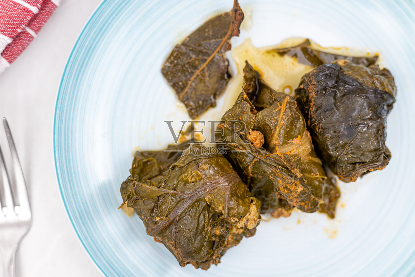 装在盘子里的碎肉卷。用甜菜和肉末做成的传统巴尔干餐。照片摄影图片