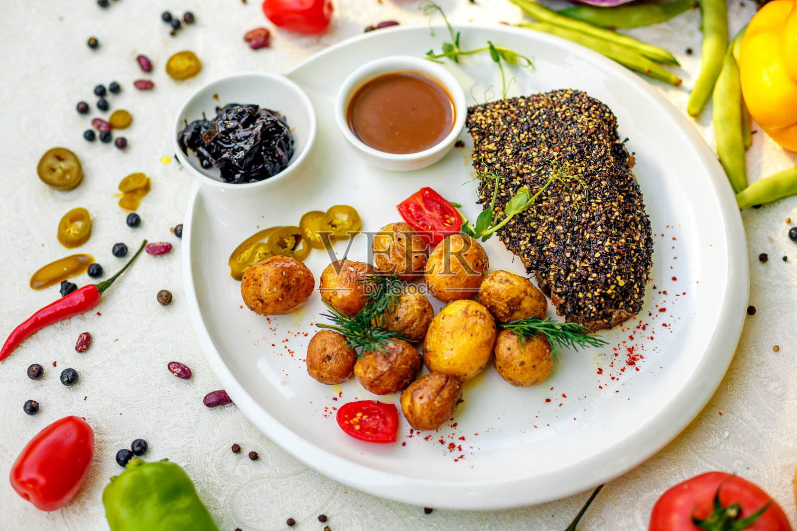 胡椒牛排配烤土豆和腌洋葱照片摄影图片