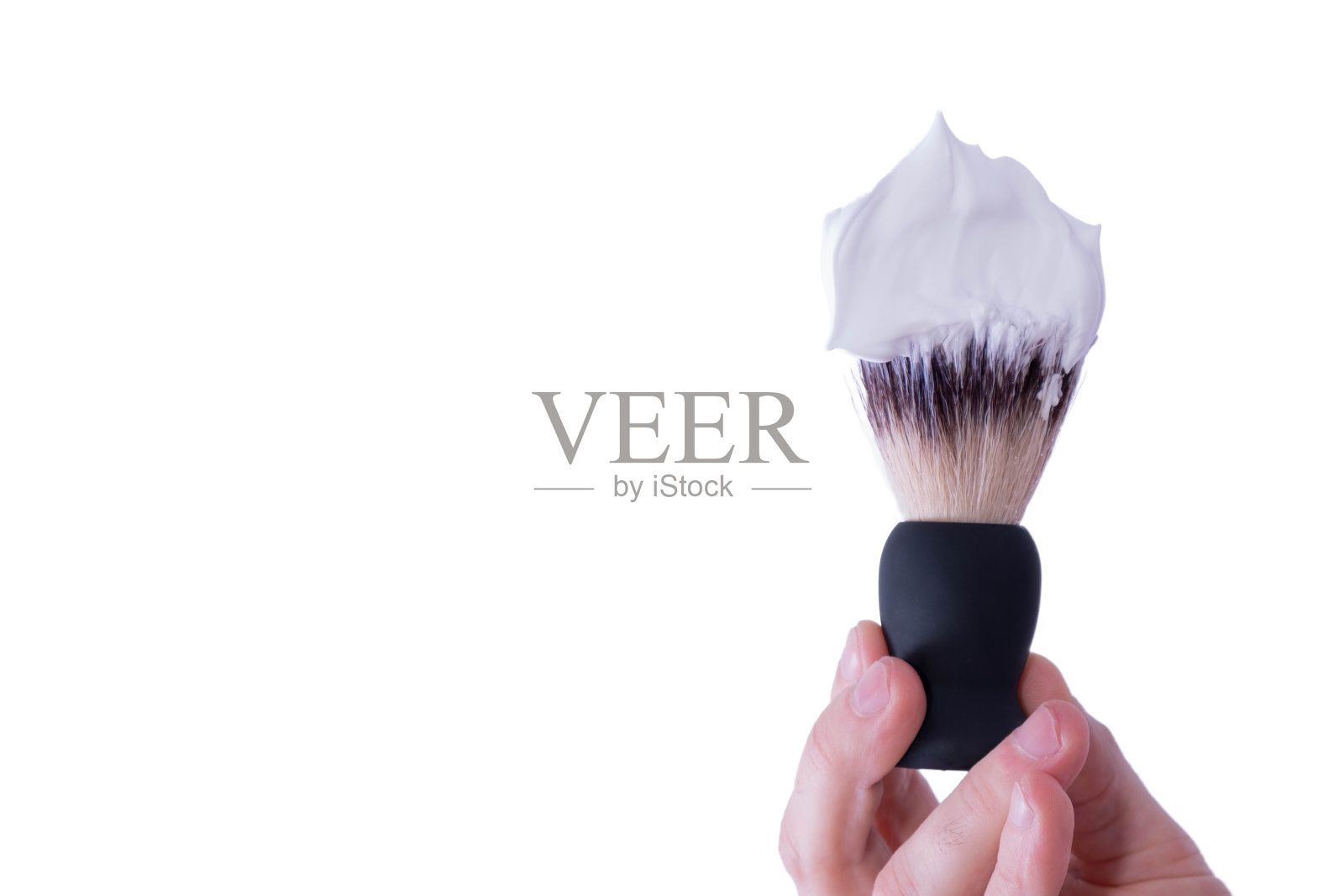 手里拿着剃须刷，上面有泡沫照片摄影图片