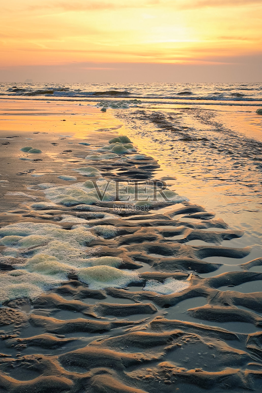 有波浪和波纹图案的沙滩，部分被泡沫覆盖照片摄影图片