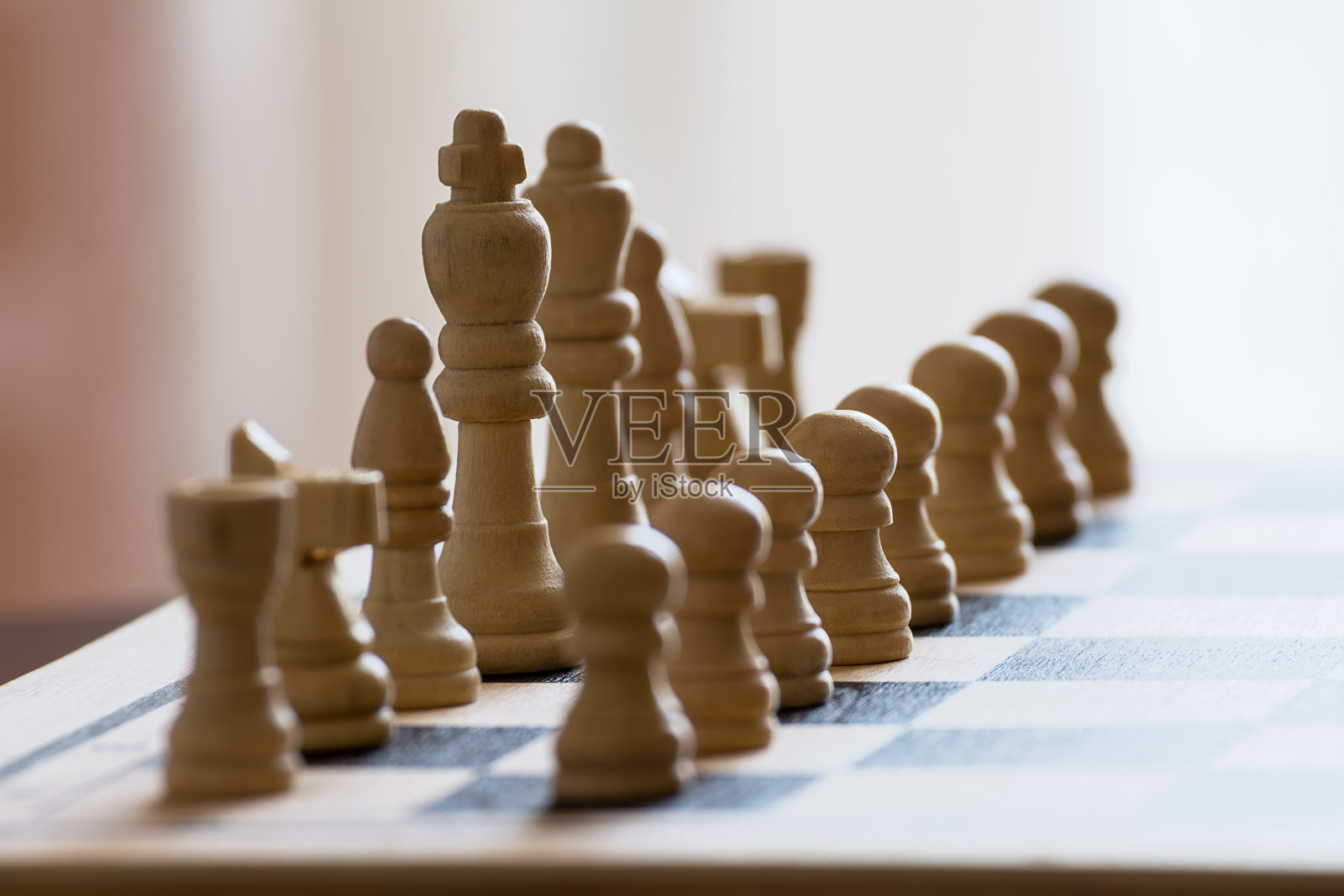 在粗糙的木制表面上的棋盘与白色棋子的裁剪视图照片摄影图片