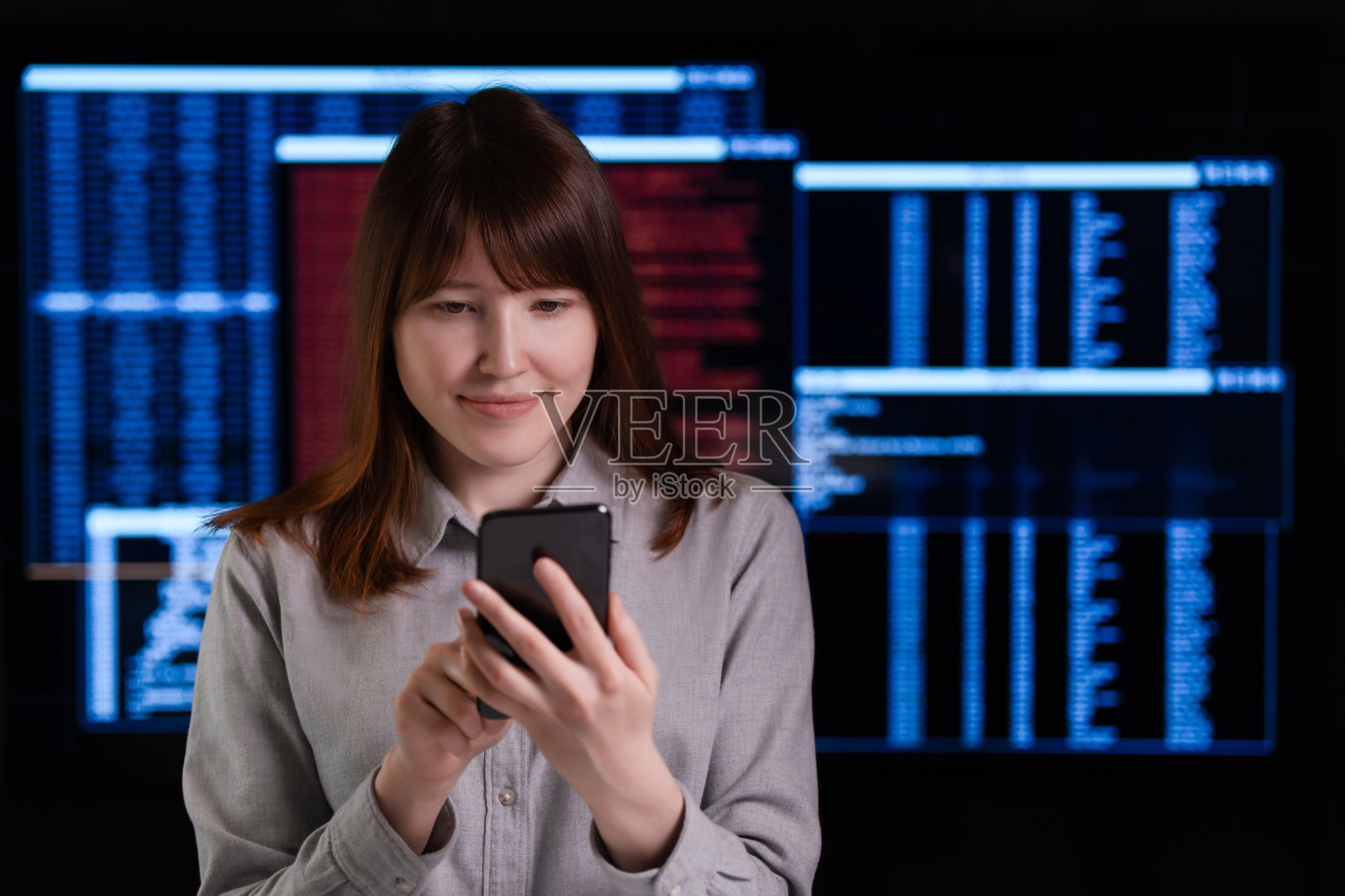 一个微笑的女性黑客正在使用手机照片摄影图片