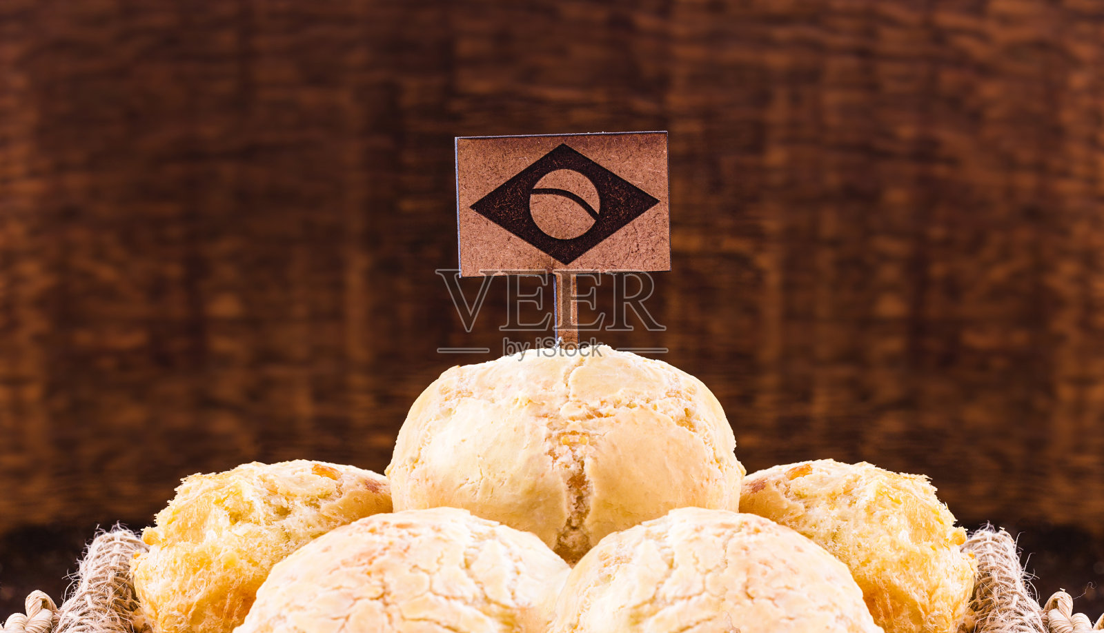 巴西奶酪面包，一个民族的激情，巴西传统创造在米纳斯吉拉斯州。在这个国家最消费的食物，一个木制的巴西国旗作为装饰。照片摄影图片