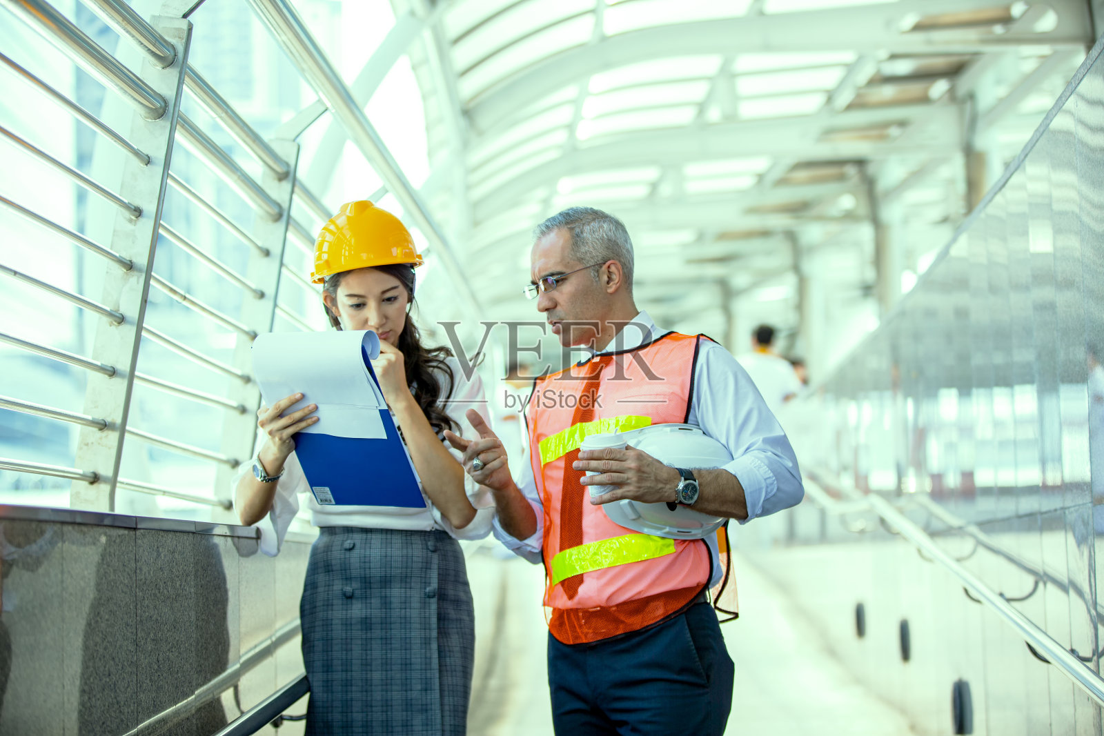 画像的多民族建筑师与蓝图和商业工业人工程师在建设大楼照片摄影图片