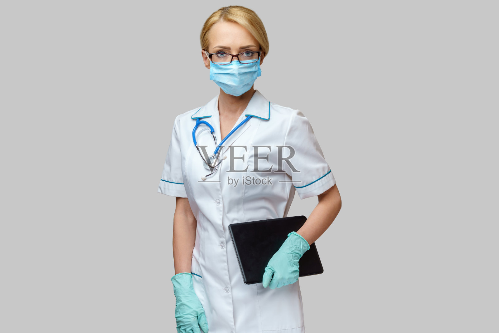 医生护士女人戴着防护口罩和手套拿着平板电脑照片摄影图片