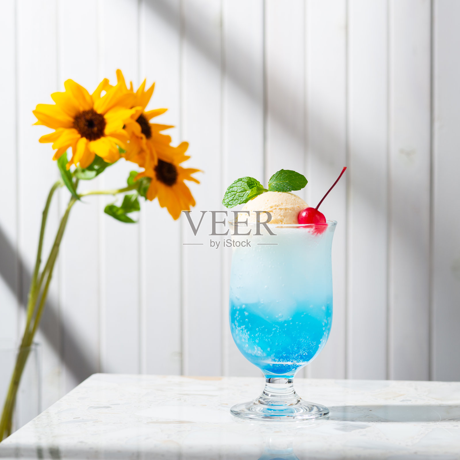 蓝色的苏打水漂浮着向日葵照片摄影图片