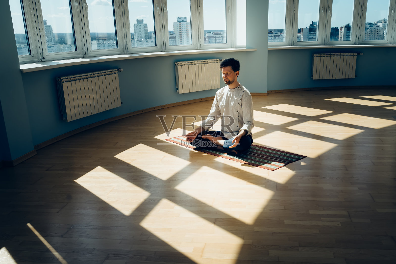 人练习瑜伽。年轻迷人的男性做呼吸练习。一个在家里打坐的人放松和休息概念的隔离。幻灯片拍摄照片摄影图片