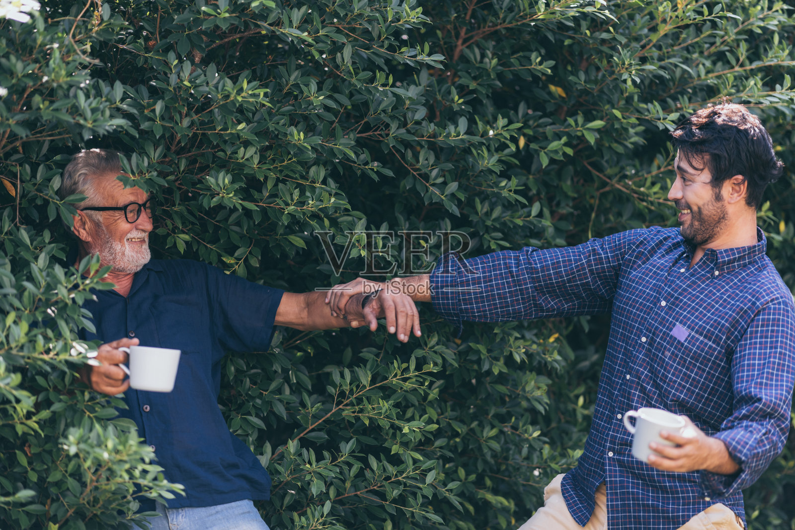 父子关系。和他一起喝咖啡的快乐的年轻人照片摄影图片