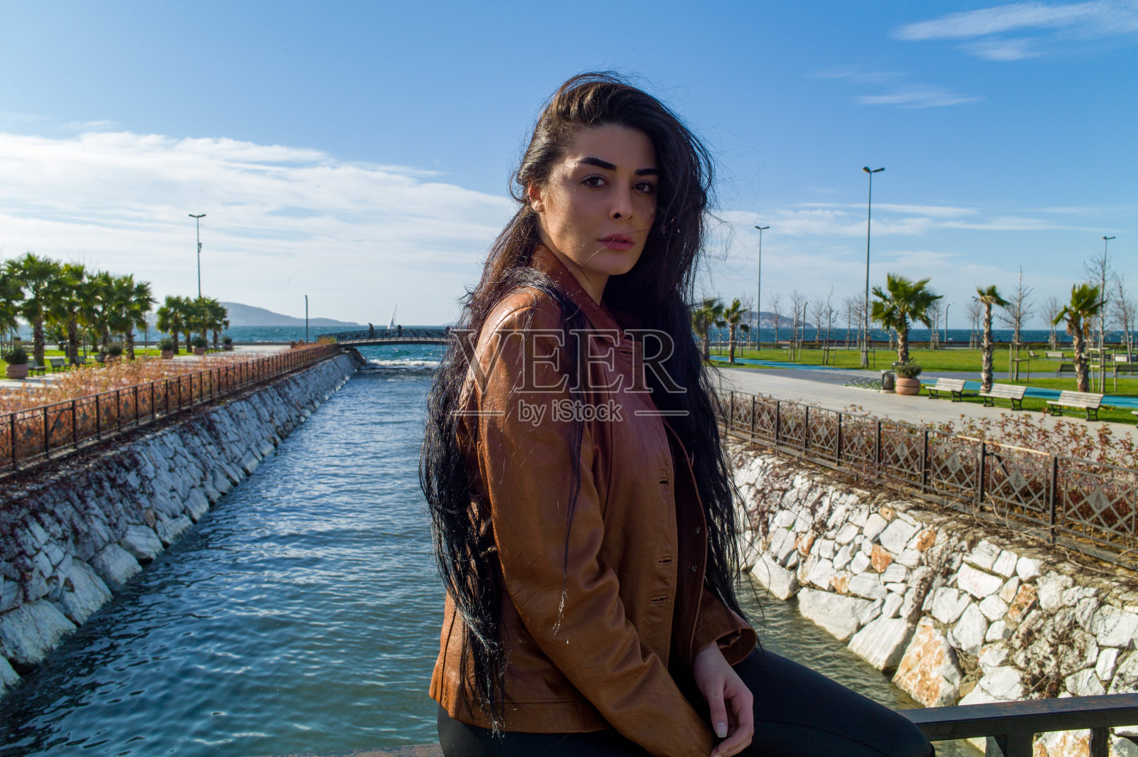 一个长发女子坐在桥上照片摄影图片