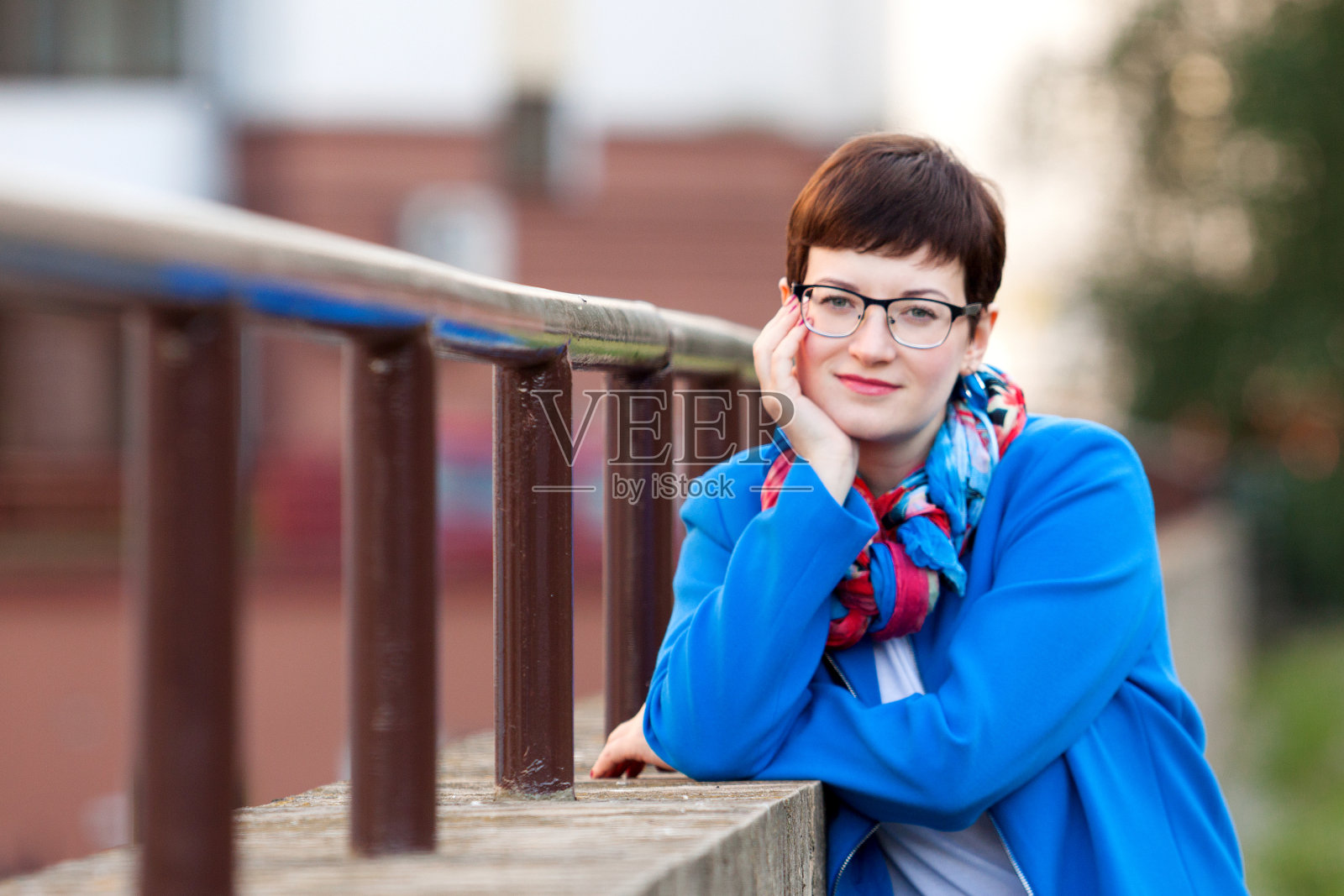 一个短发的黑发女人穿着休闲的城市服装，蓝色调的微笑照片摄影图片