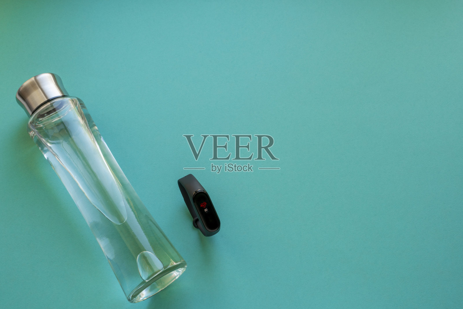 蓝色背景上的水瓶和健身手镯。在家运动照片摄影图片