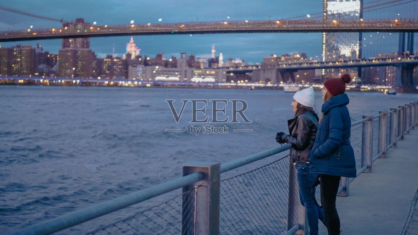 在纽约哈德逊河上放松，欣赏曼哈顿城市灯光的美丽夜景照片摄影图片