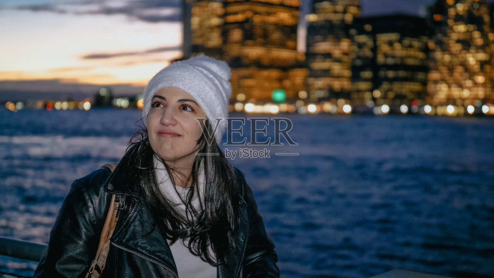 年轻女子欣赏夜晚曼哈顿天际线的美妙景色照片摄影图片