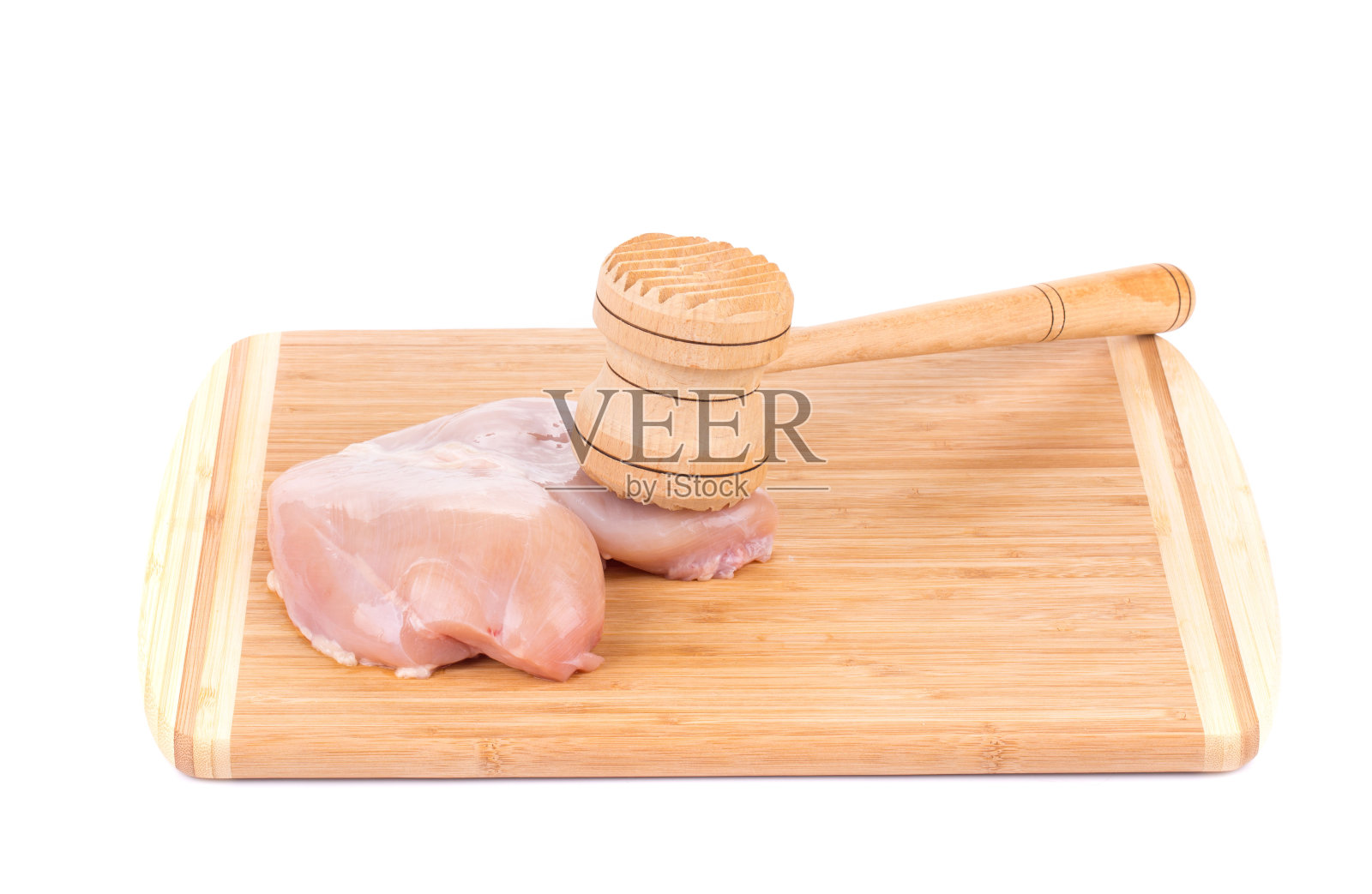 生鸡胸肉和木槌放在木板上。照片摄影图片