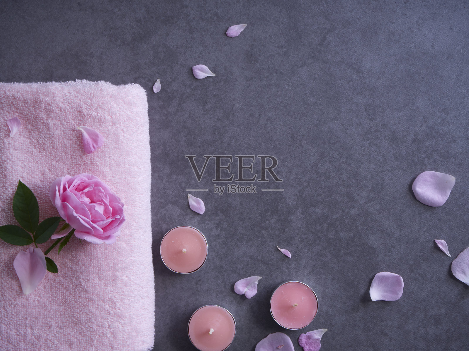 水疗组合粉红玫瑰和蜡烛在灰色的背景照片摄影图片