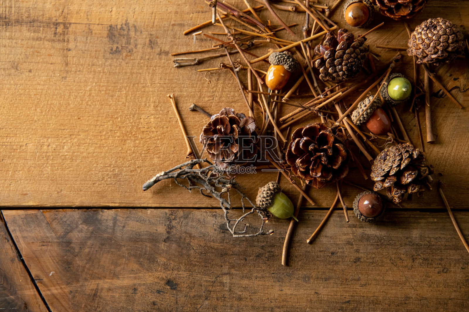 木制背景与人工秋天的橡子，松果和树枝。照片摄影图片