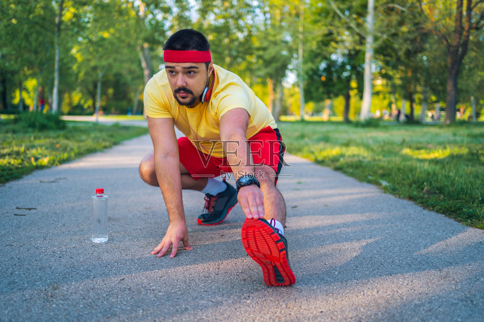 男人在跑步前伸伸腿照片摄影图片