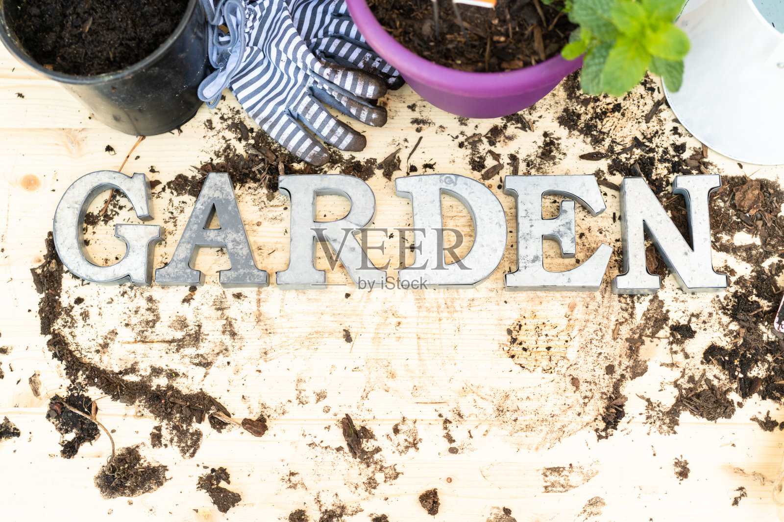 在溢出的土壤周围用金属字母标记GARDEN照片摄影图片