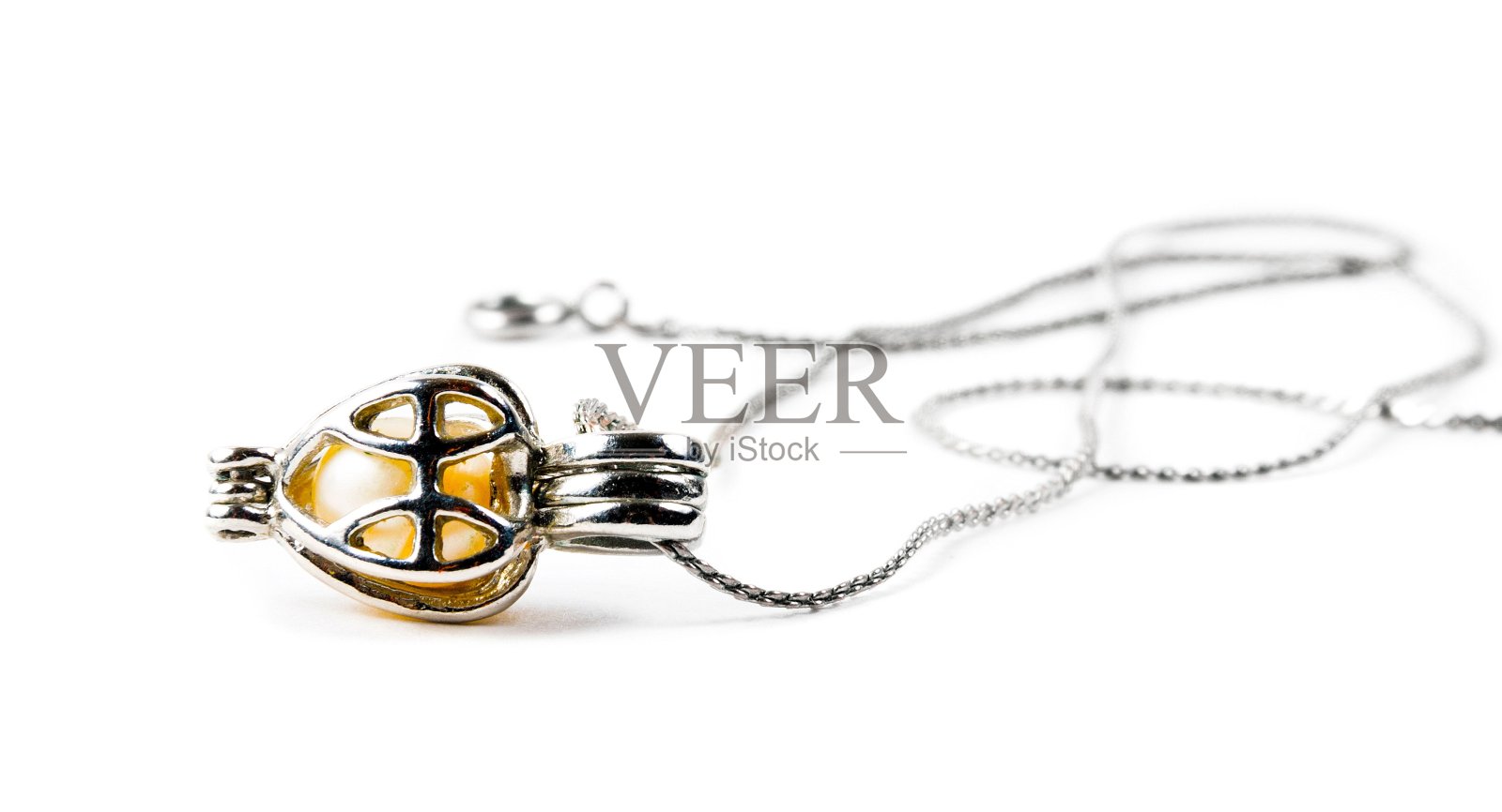 银色吊坠特写在白色的背景照片摄影图片