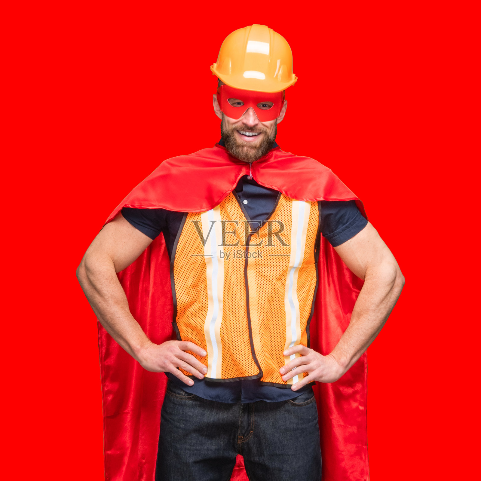 白人年轻男性超级英雄站在彩色背景前，穿着斗篷照片摄影图片