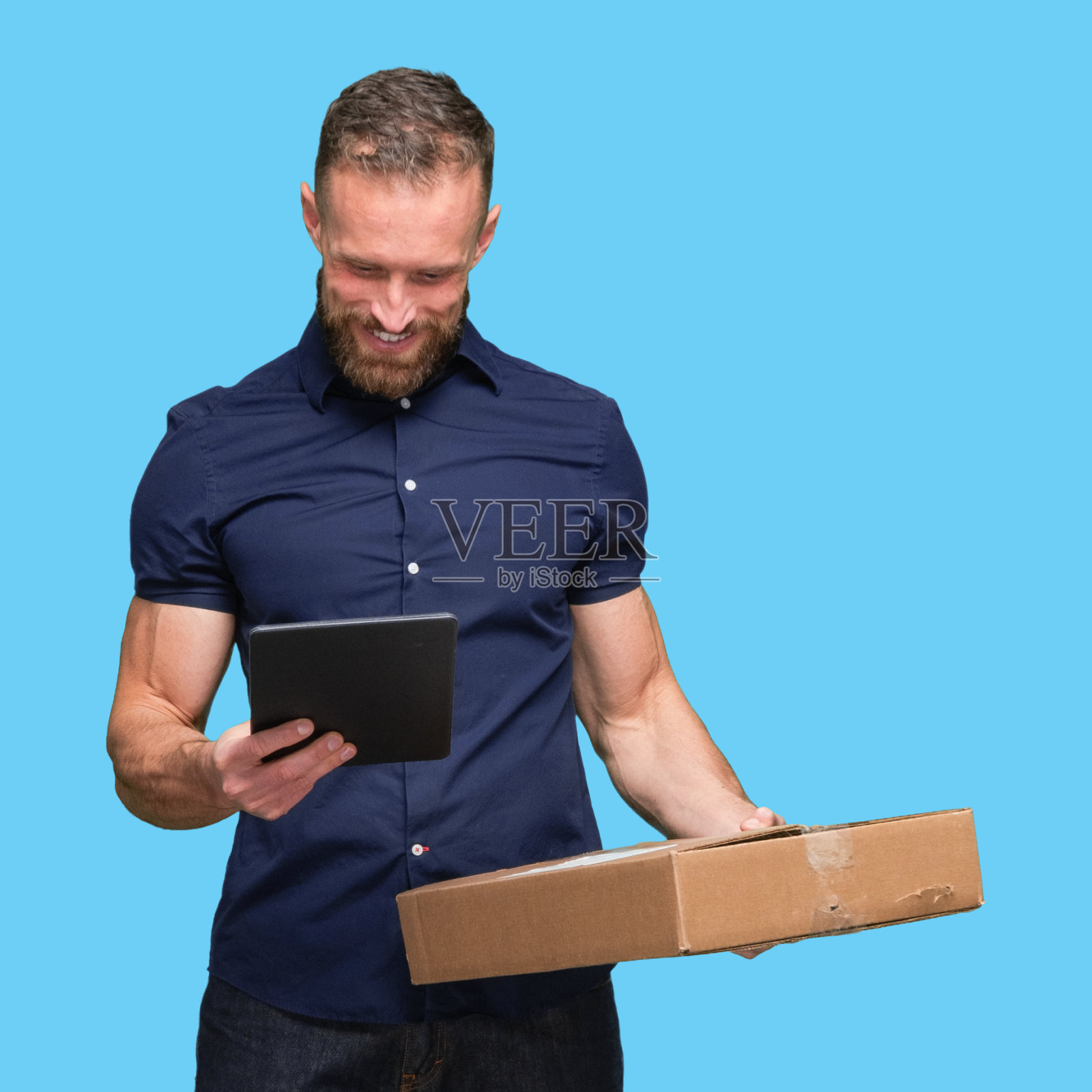 白人年轻男性体力劳动者站着，拿着容器，使用数码平板电脑照片摄影图片