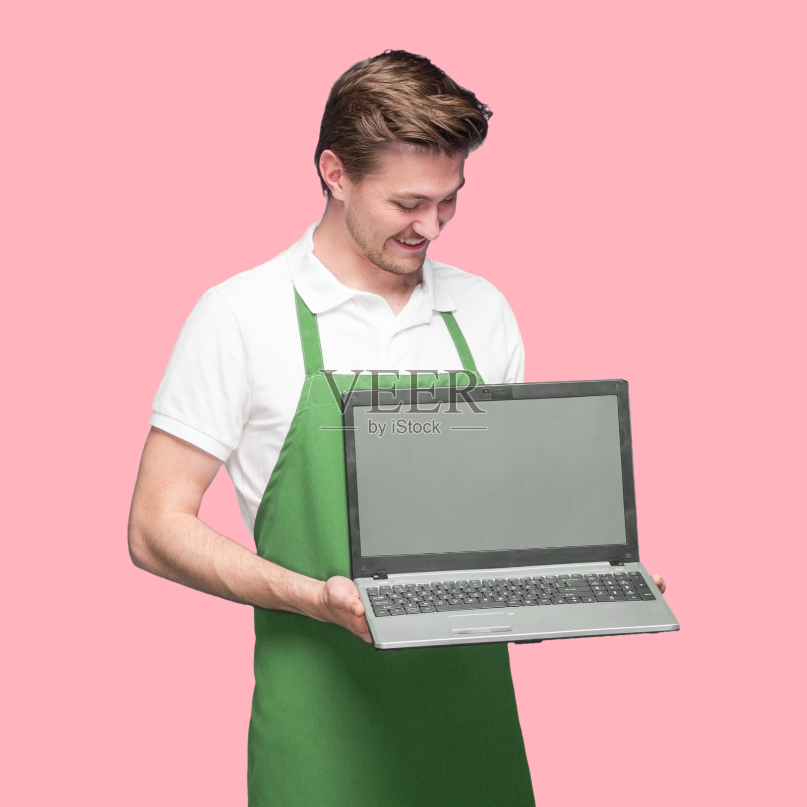 白人年轻男性咖啡师站在彩色背景穿着polo衫和使用电脑照片摄影图片