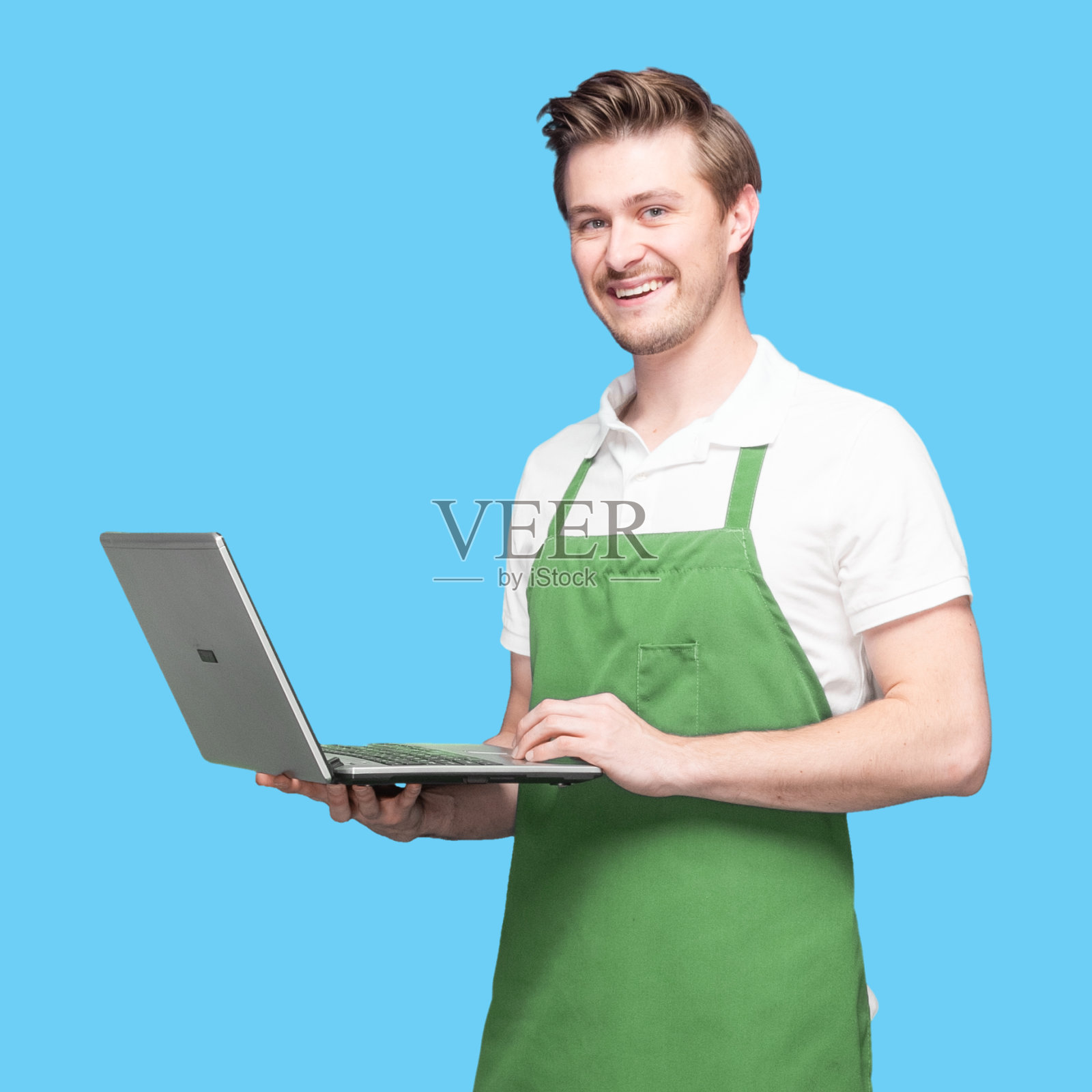 白人男咖啡师穿着围裙站着用笔记本电脑照片摄影图片