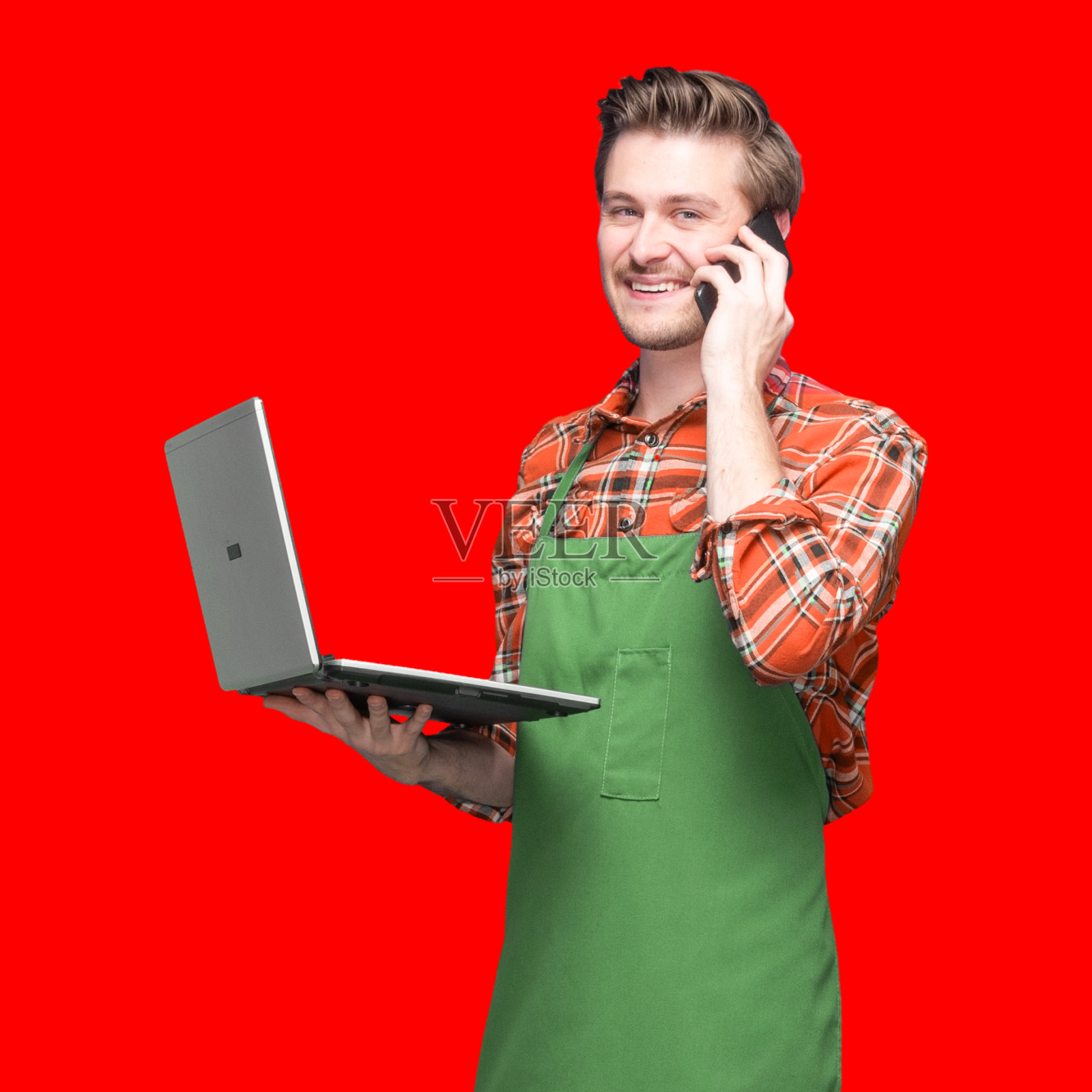 白人年轻男性咖啡师穿着衬衫站在有色背景前使用智能手机照片摄影图片