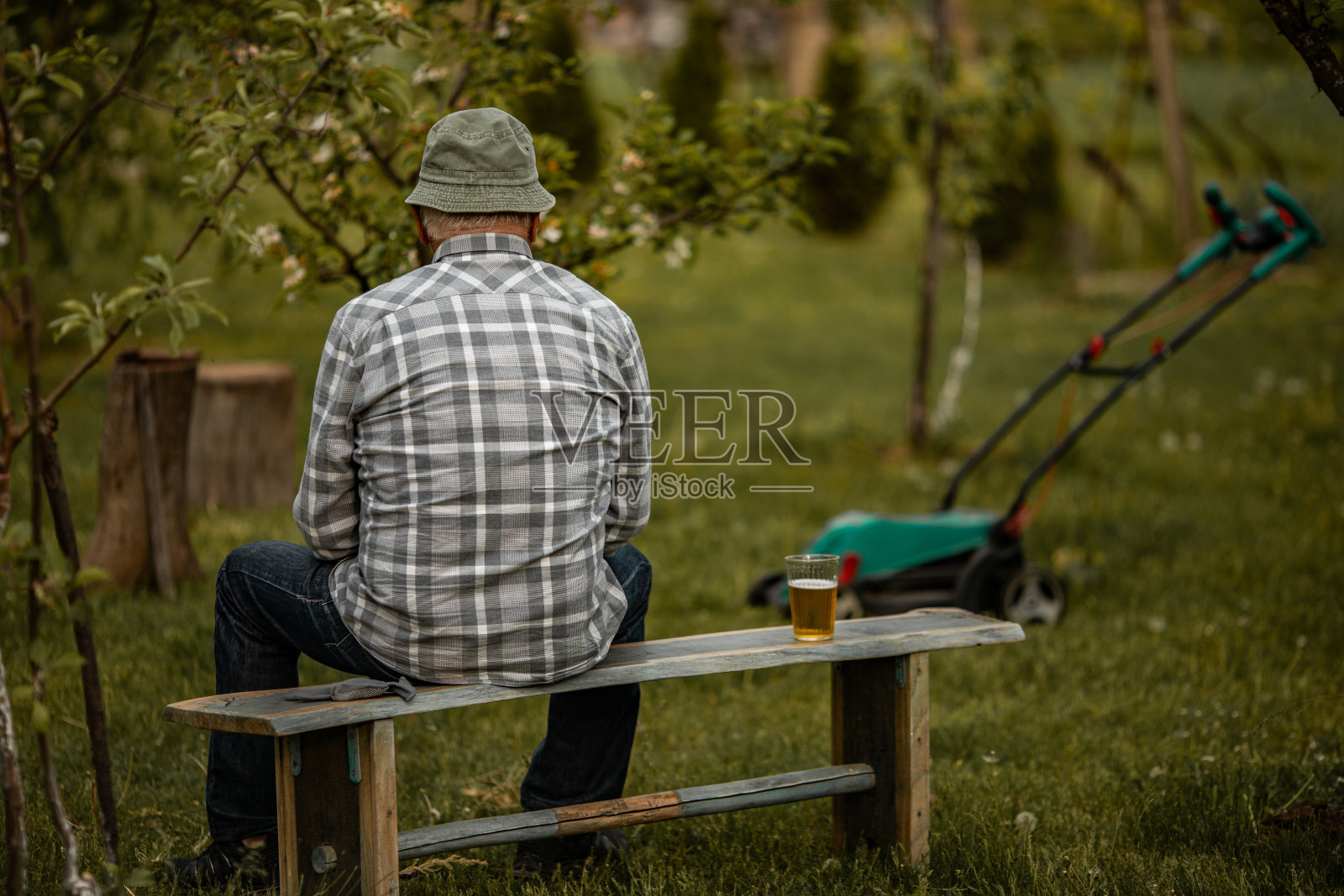 老人下班后用割草机放松照片摄影图片