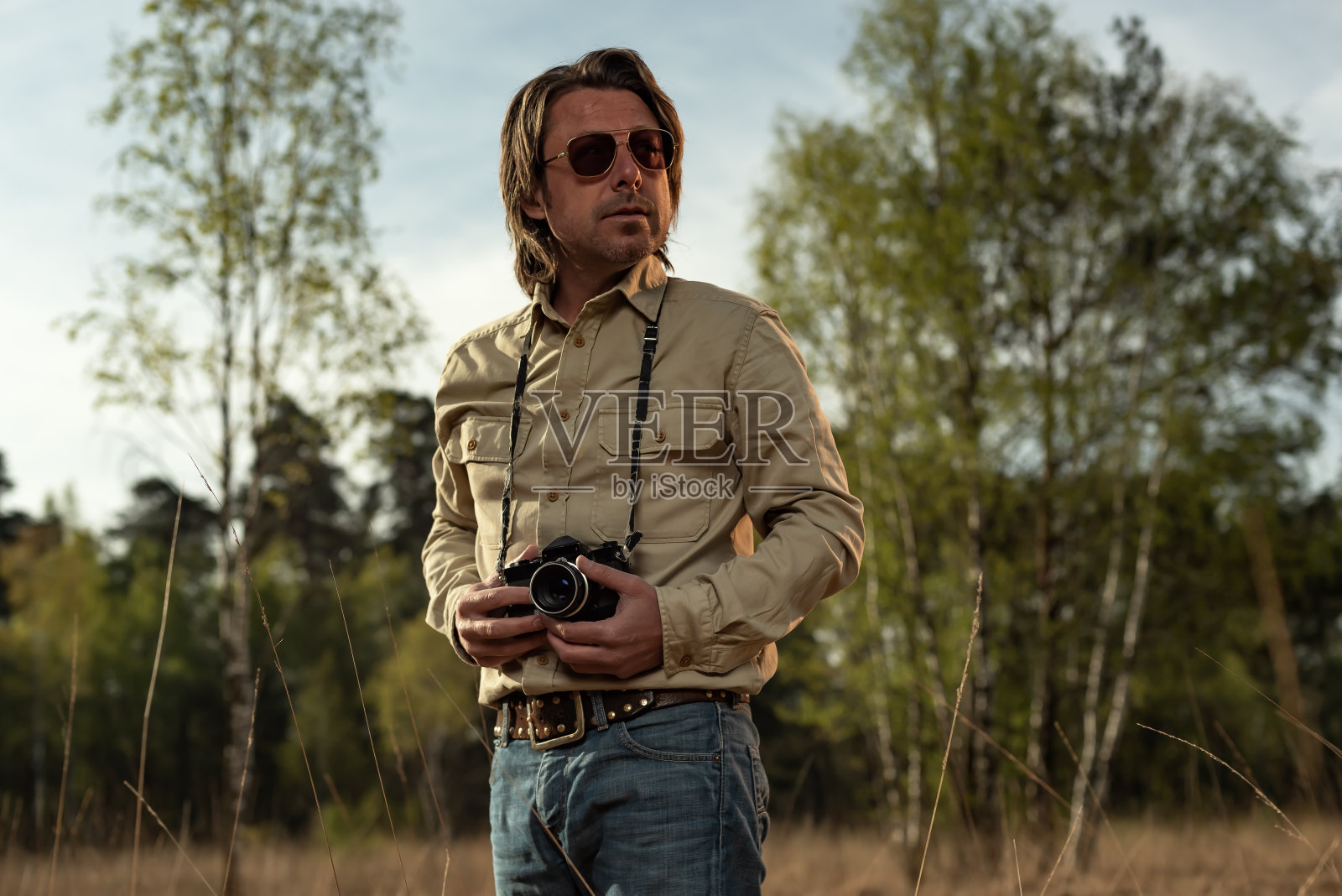 春天的日出，戴着墨镜的自然摄影师在自然保护区拍摄。照片摄影图片