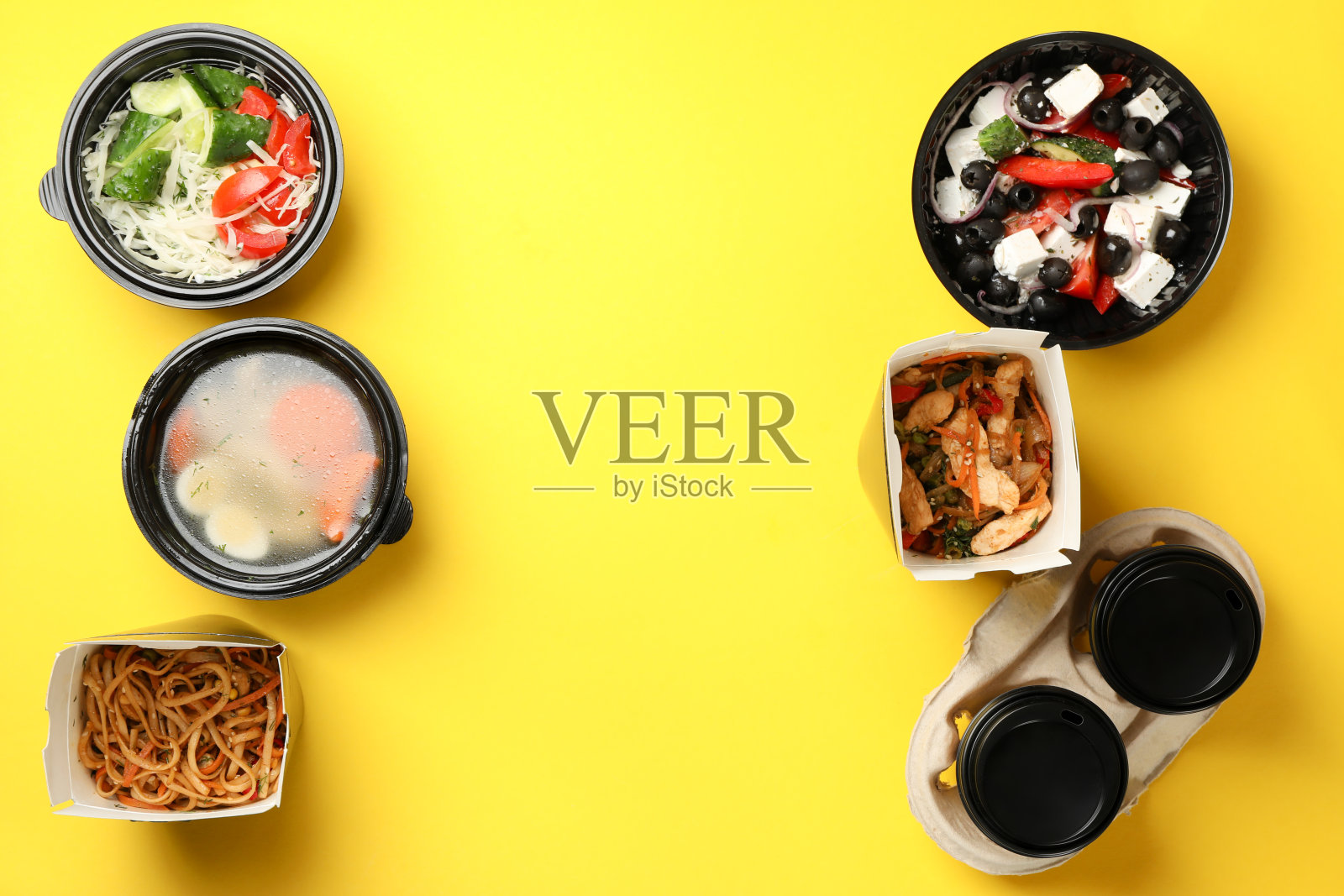 食品交付。黄色背景的外卖盒里的食物照片摄影图片