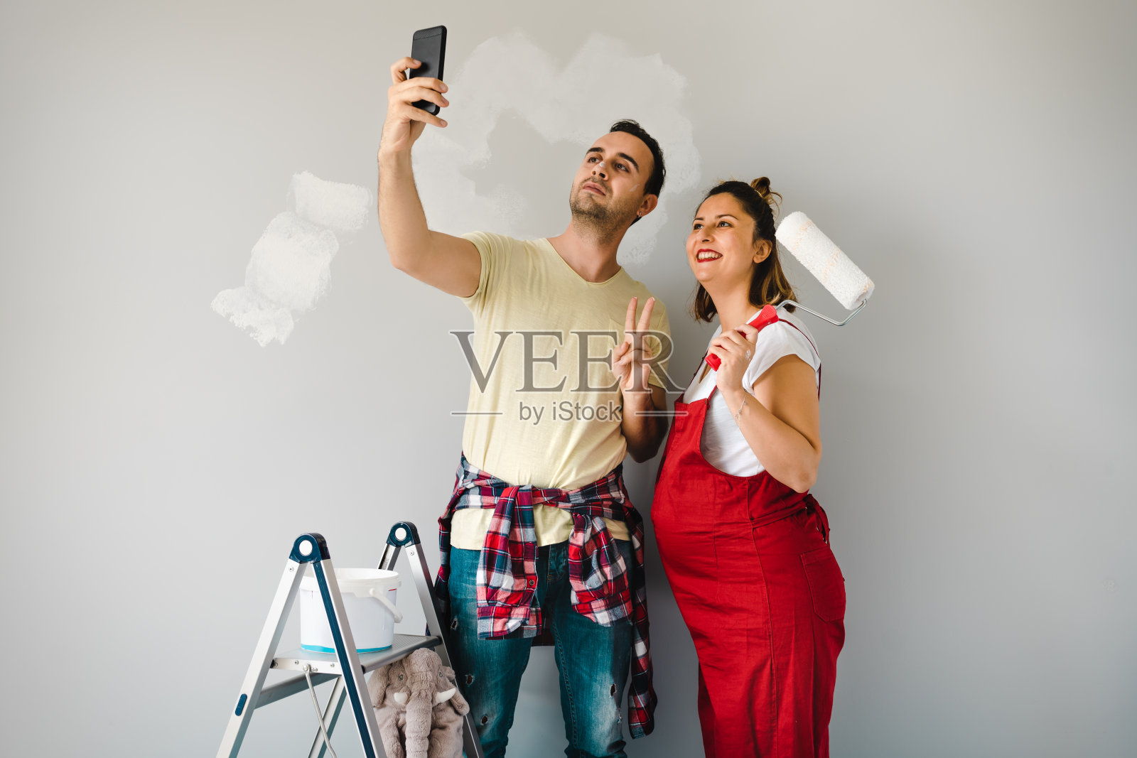 一对年轻夫妇在装修苗圃时为他们的墙壁选择合适的颜色照片摄影图片