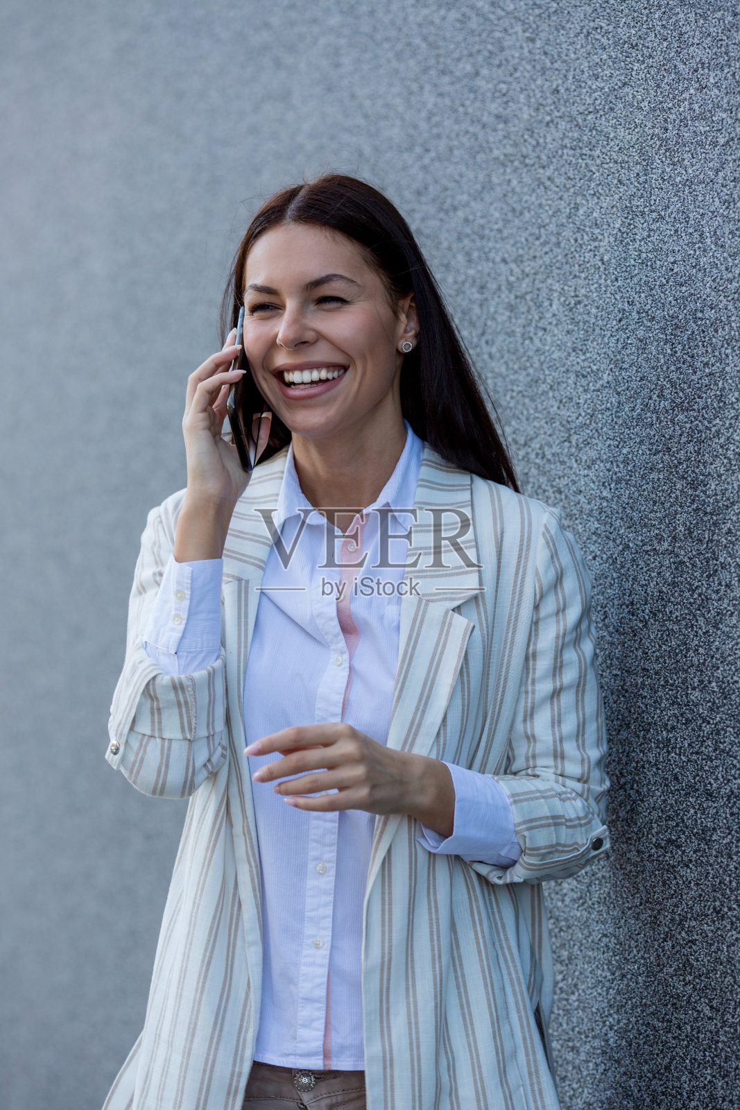 年轻的微笑美丽的女人走在城市的街道上讲手机照片摄影图片