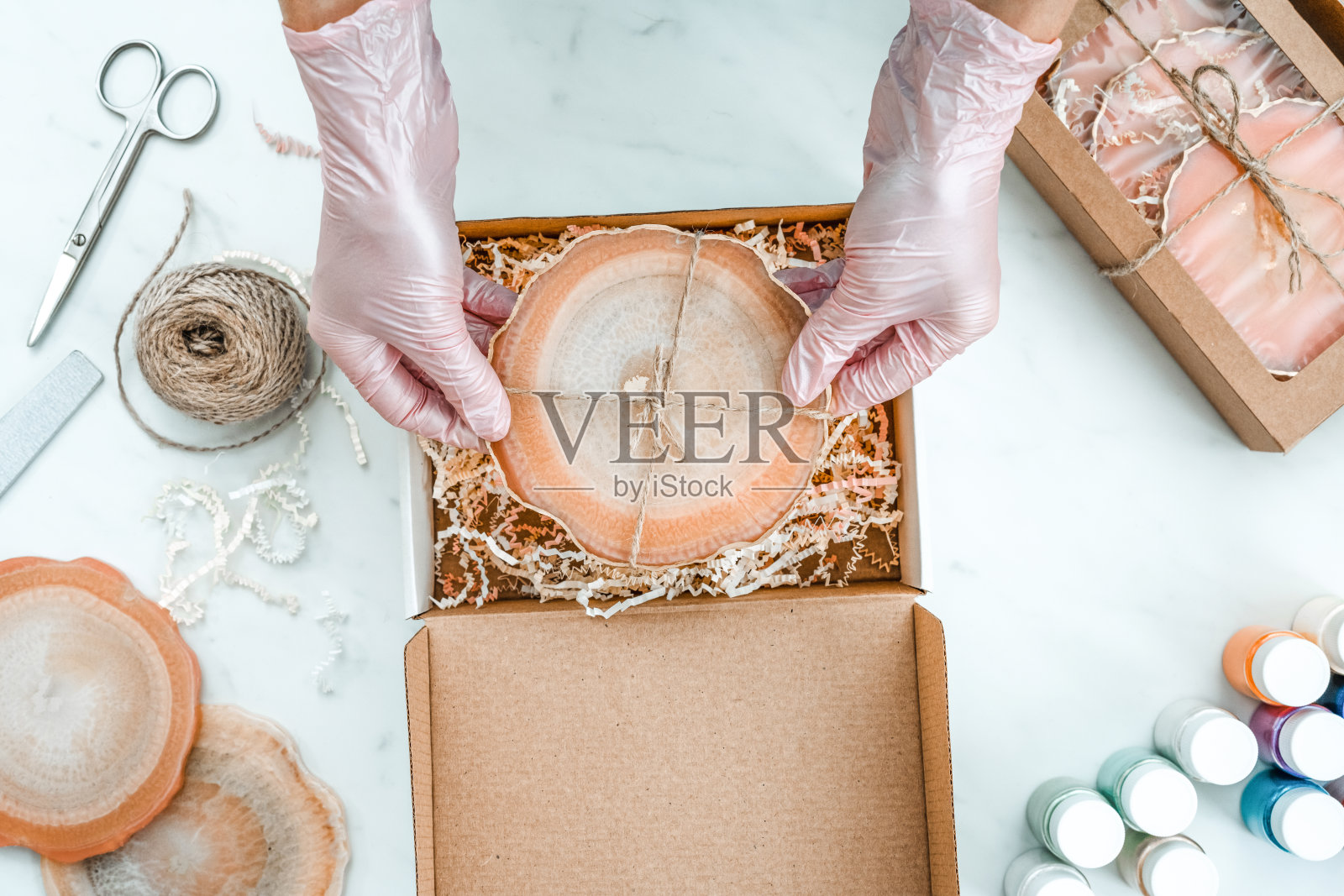 创造力和工艺。一个小女孩用树脂做杯垫。礼品包装。装饰包装。对商业想法。远程工作，在家工作。艺术杯垫。照片摄影图片