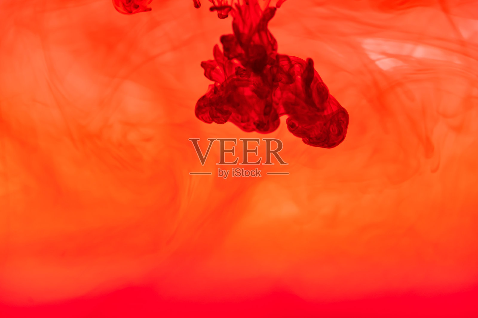 接近红色油墨的液体液体和烟雾抽象背景。照片摄影图片