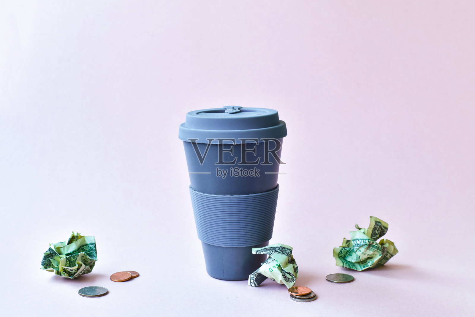 可重复使用的咖啡杯，周围是零钱照片摄影图片