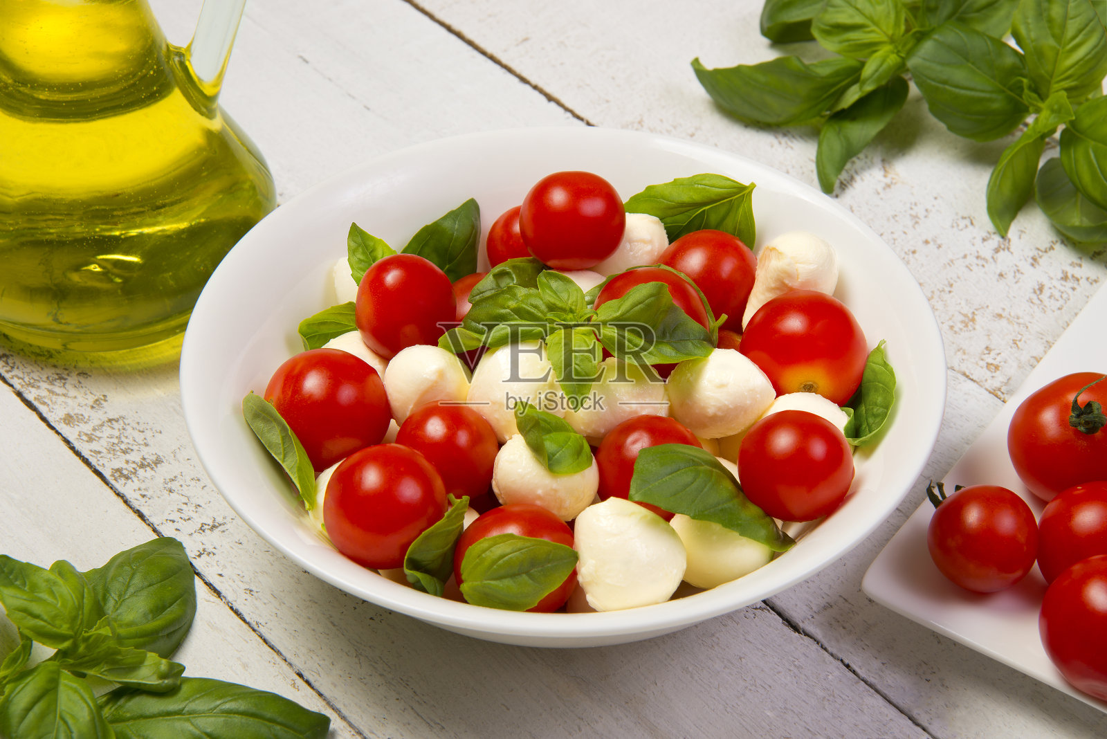 白木桌上的碗里装着卡普里沙拉。选择的重点。照片摄影图片