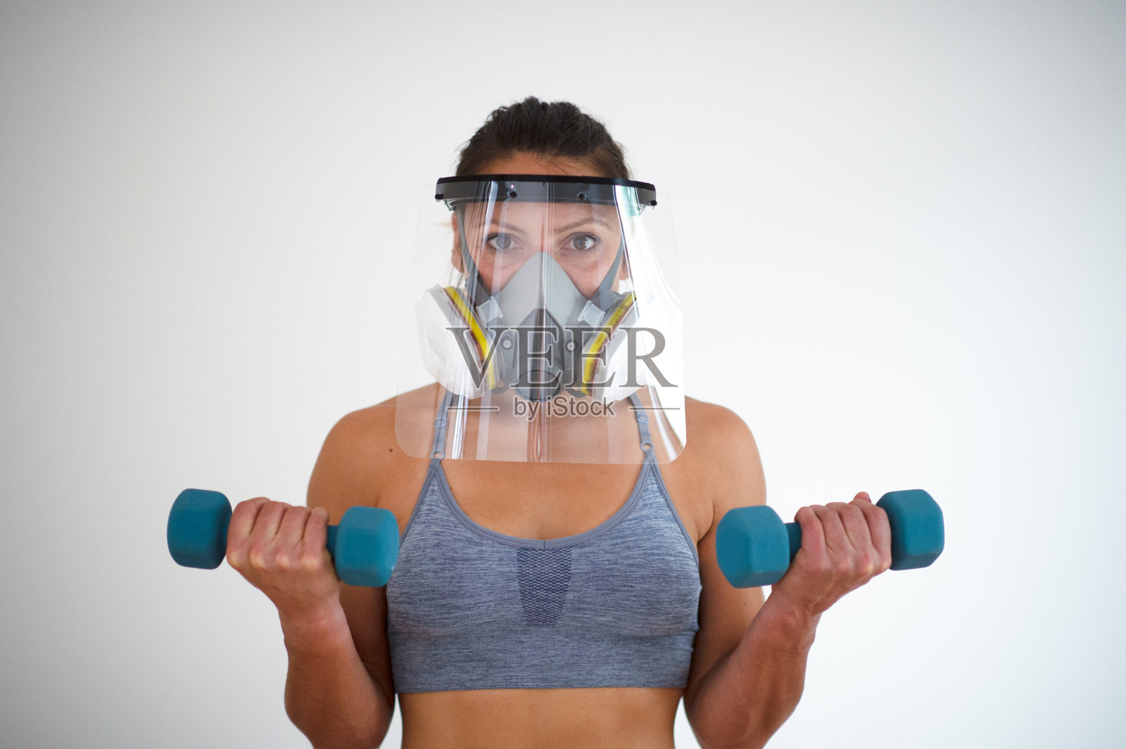 保护脸部齿轮肌肉发达的年轻女子二头肌卷曲白色背景肖像照片摄影图片