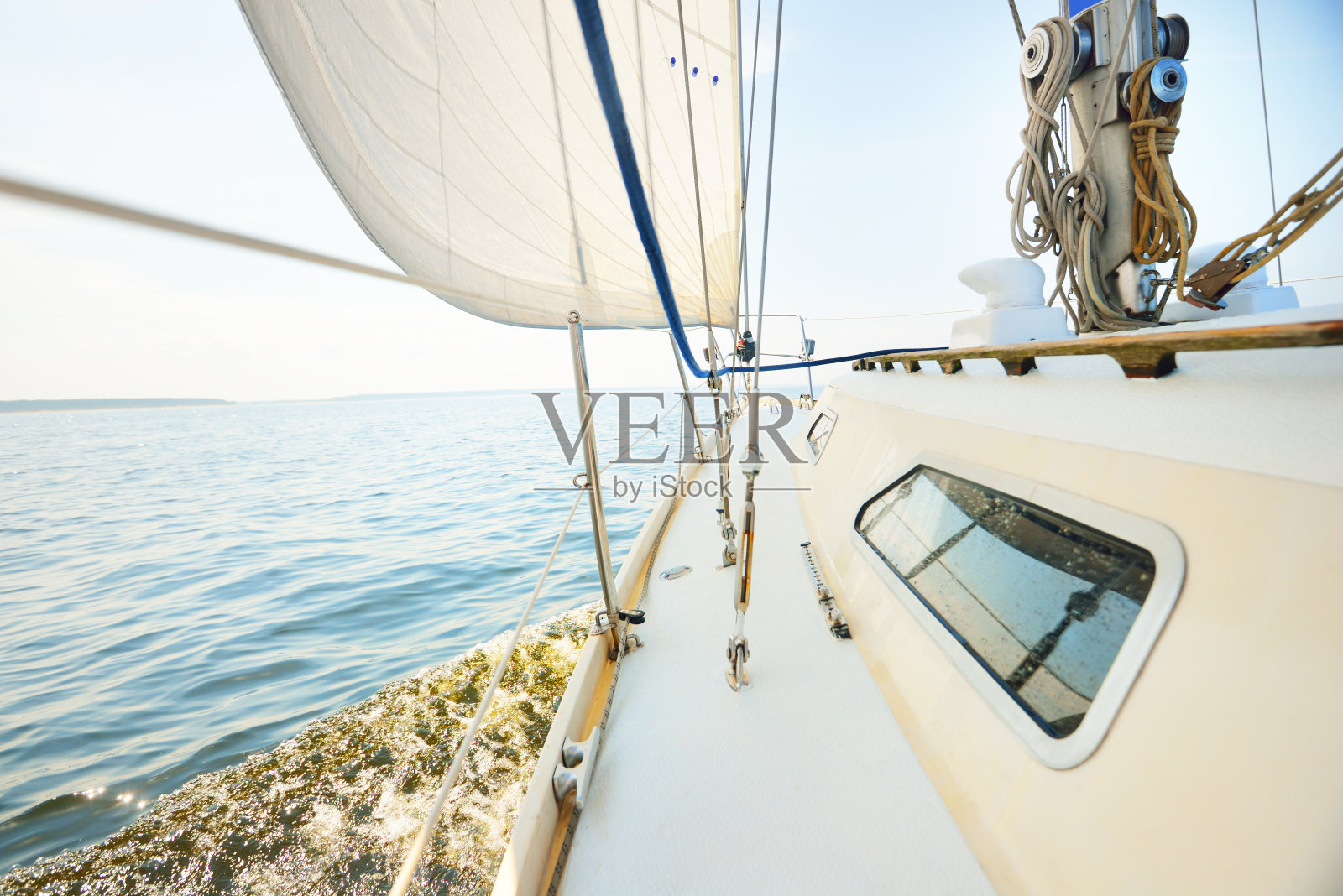 在一个晴朗的日子里，一艘白色游艇在公海上。从甲板到船头，桅杆和帆，索具设备的近景。夏季大西洋航行靠近西班牙和非洲照片摄影图片
