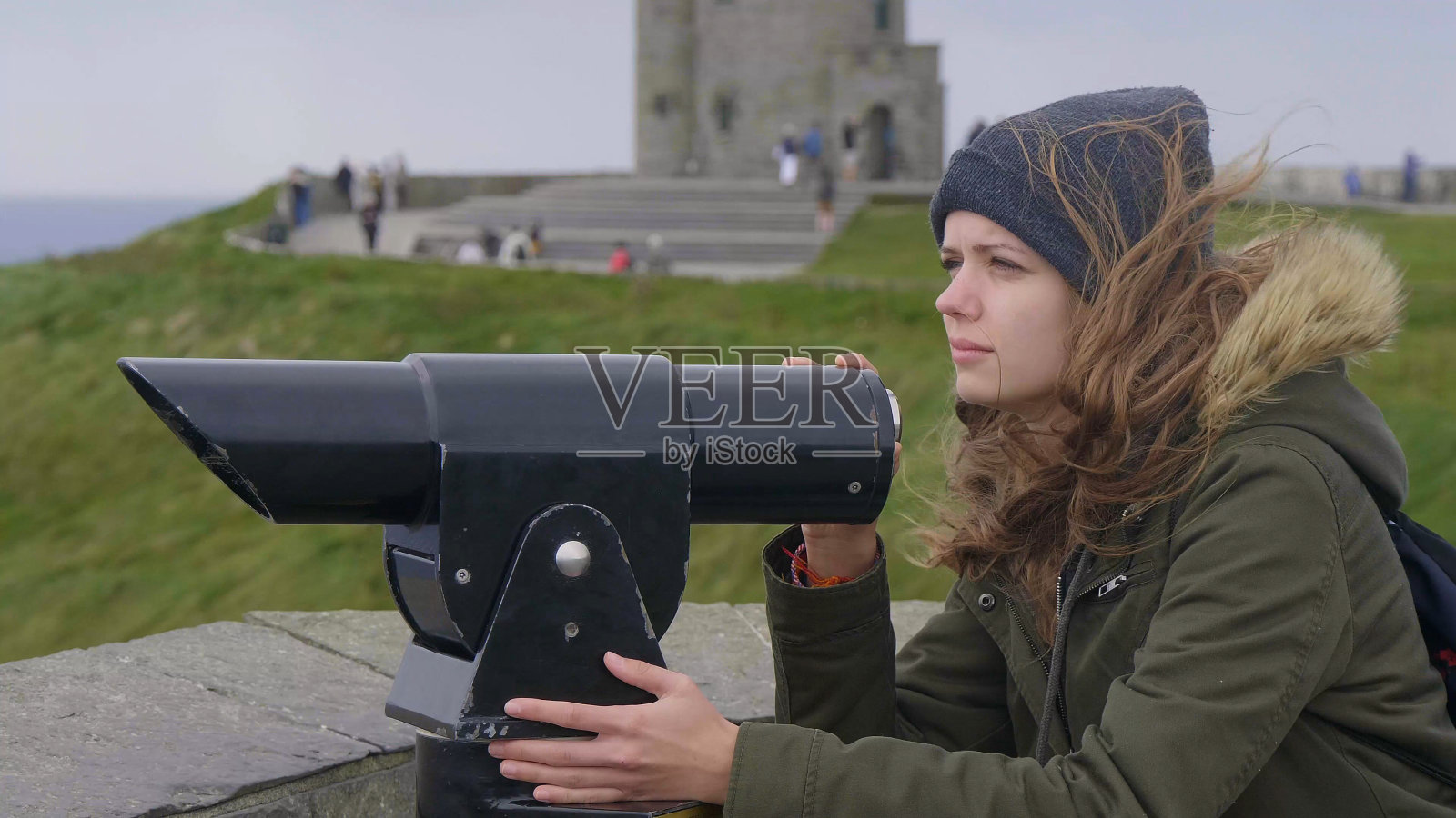 年轻女子透过小望远镜观察周围照片摄影图片