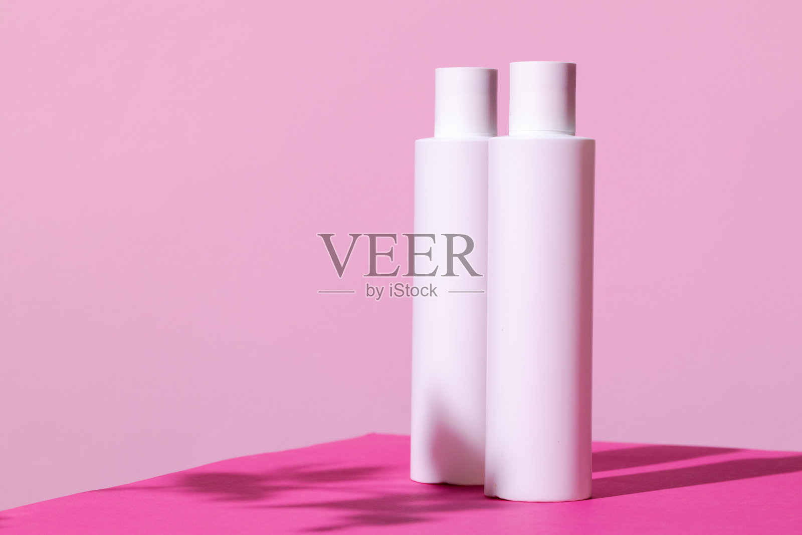 亮粉色背景的护肤品容器照片摄影图片