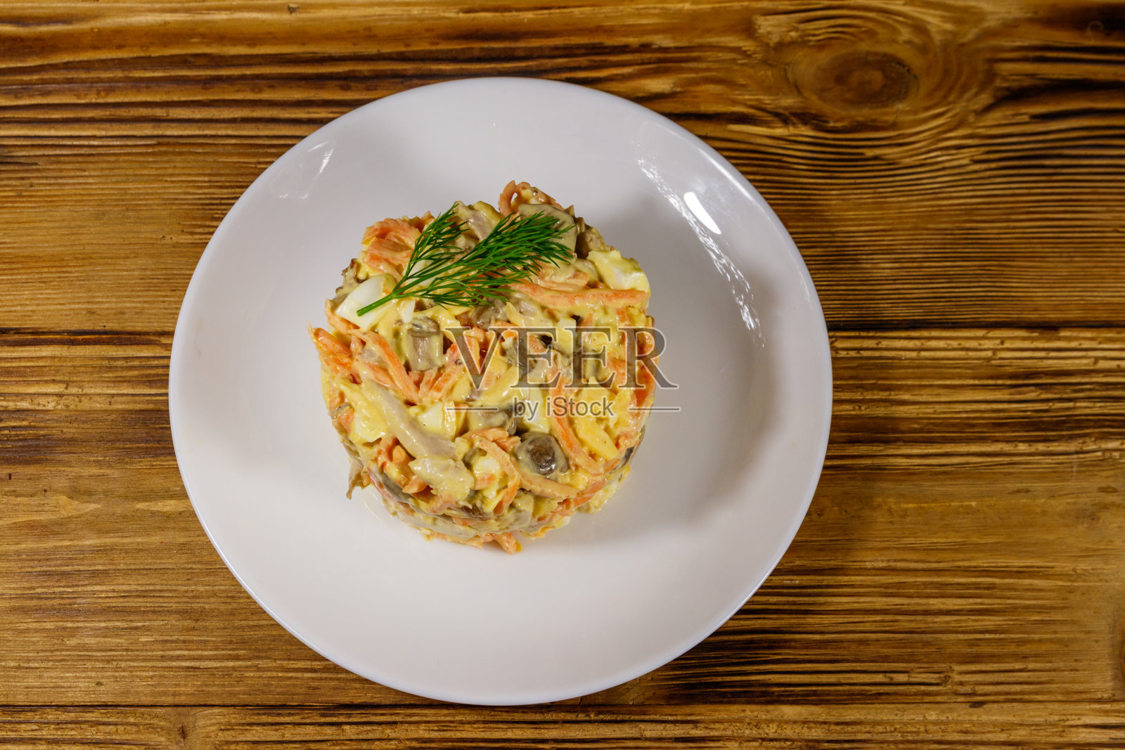 美味的沙拉配鸡胸肉，烤蘑菇，胡萝卜，磨碎的奶酪，鸡蛋和蛋黄酱放在木桌上。俯视图照片摄影图片