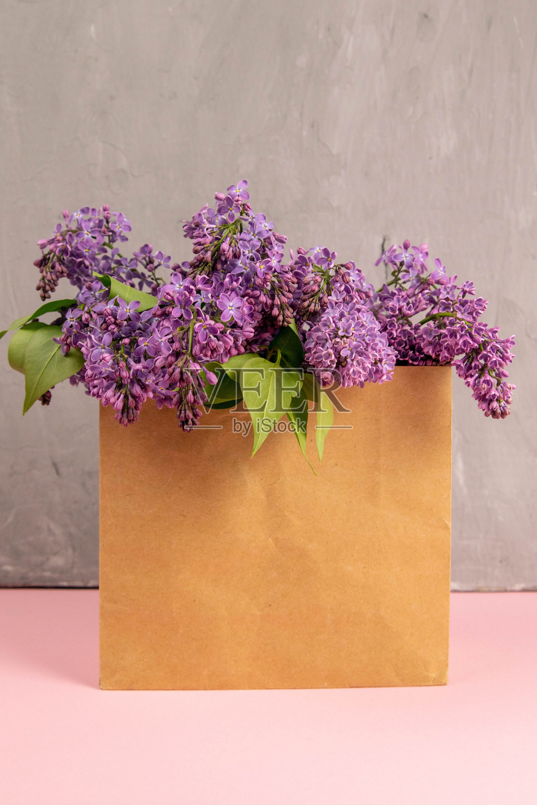 纸工艺品包装与丁香花在粉红色的背景。创造性的成分。春季大甩卖，自然美、有机化妆品店市场大旗照片摄影图片