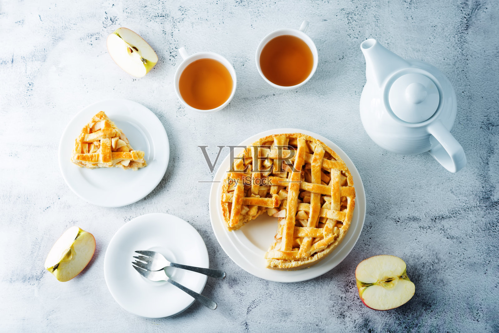 苹果蛋糕，新鲜的苹果片和几杯茶照片摄影图片