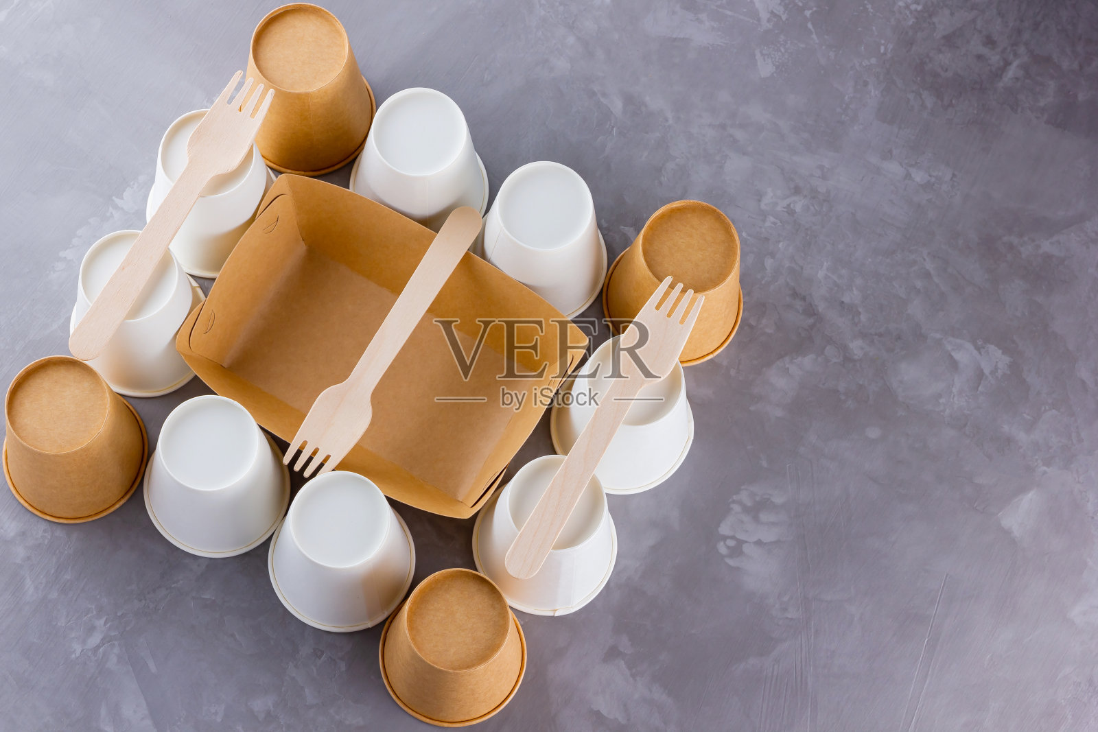 “零浪费”。一次性餐具。用竹木和纸制成的环保一次性用具，在灰色的背景上。纸杯，快餐容器和竹木制餐具照片摄影图片