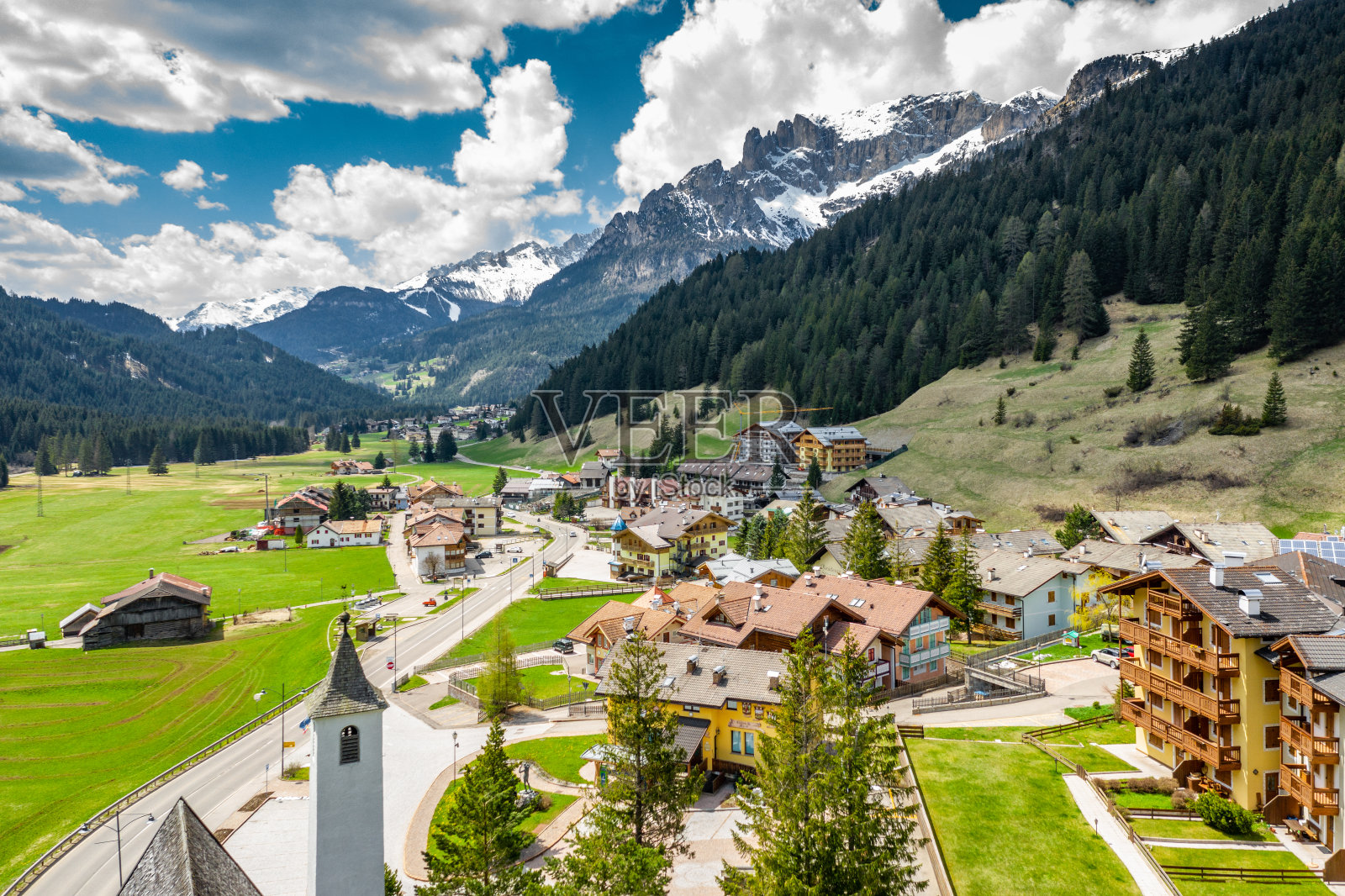 鸟瞰图山谷与木屋，绿色的山坡的意大利山脉，特伦蒂诺，丰塔纳佐，巨大的云在一个山谷，屋顶的定居点，绿色的草地，白云石的背景照片摄影图片