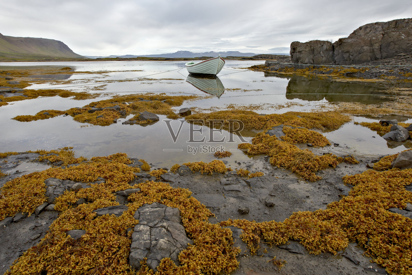 白色的小船用绳子系在山间风景中照片摄影图片