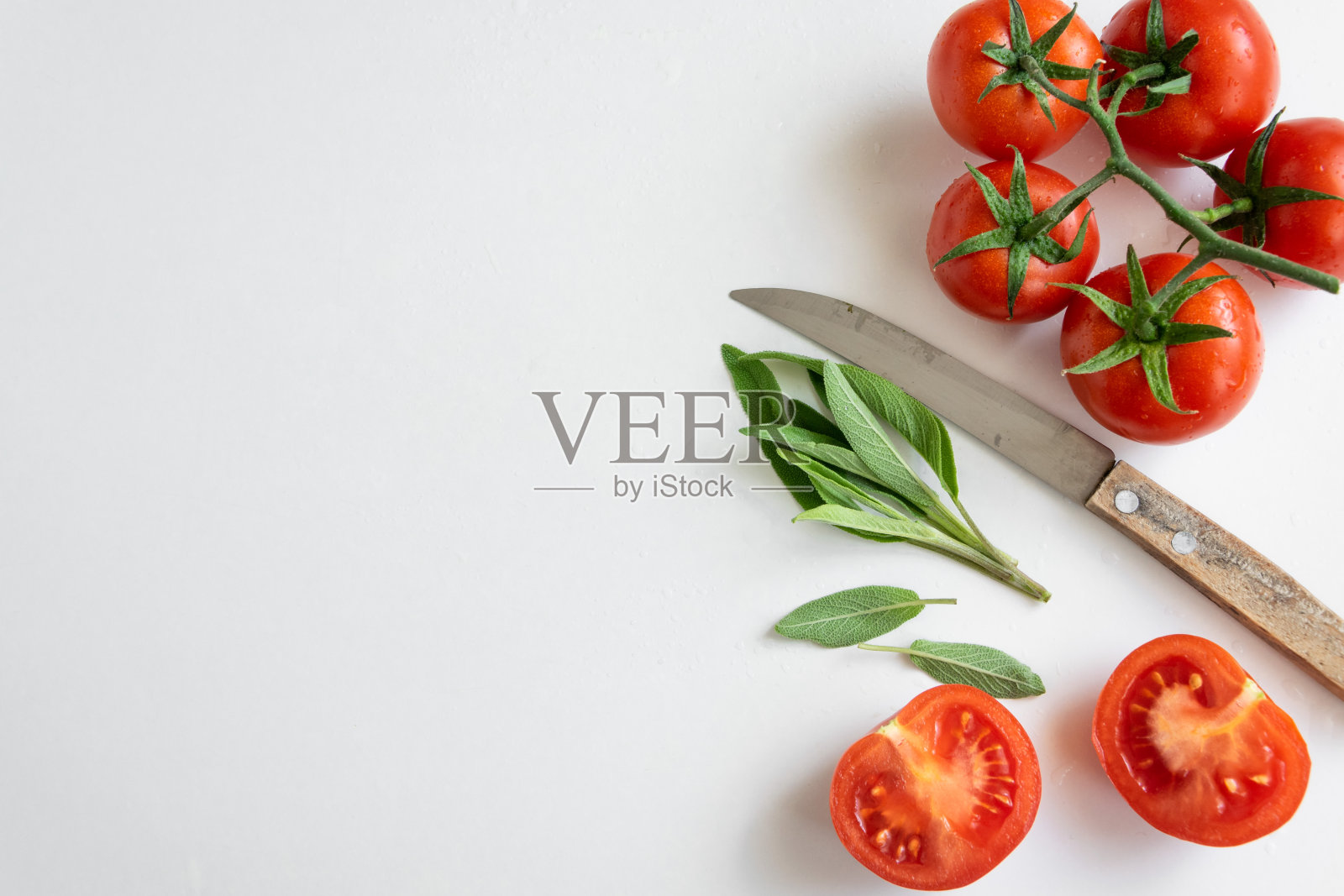 健康的食物背景-生西红柿和野生草本植物在白色的背景，鲜艳的颜色，维生素食物照片摄影图片